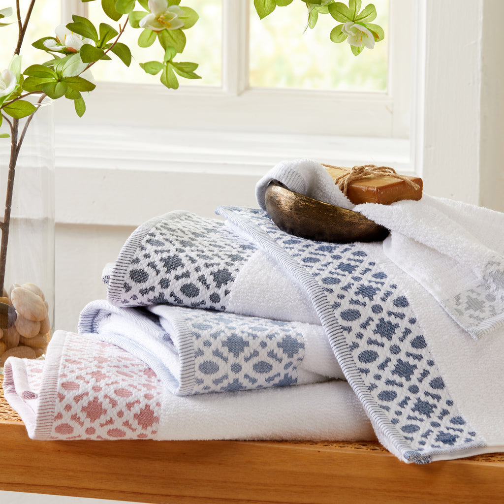 Nitra Collection Cotton Luxury Bath Towels by Market & Place featuring premium 100% cotton construction with an elegant geometric dobby border. Available in multiple colors and set configurations, including bath towels, hand towels, and washcloths, shown folded and stacked to highlight their soft, plush, and absorbent texture.