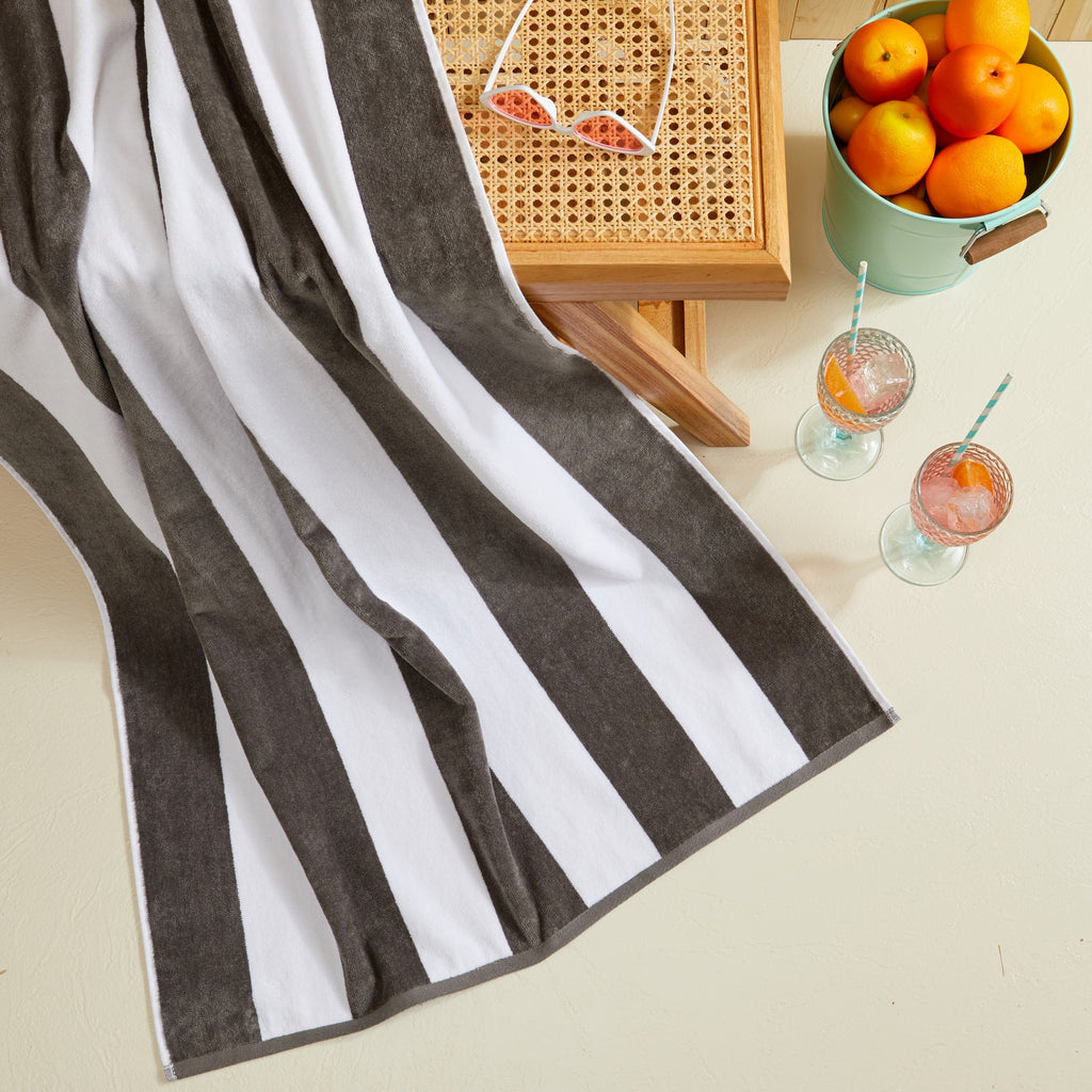Marina Collection cotton cabana stripe beach towels in assorted colors and sizes, featuring classic striped designs and soft, absorbent 100% cotton velour construction, shown folded, stacked, and styled for poolside and beach use.