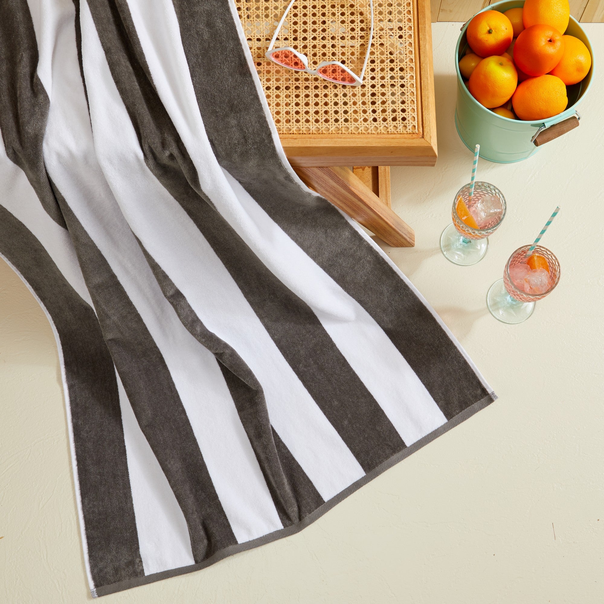 Marina Collection cotton cabana stripe beach towels in assorted colors and sizes, featuring classic striped designs and soft, absorbent 100% cotton velour construction, shown folded, stacked, and styled for poolside and beach use.