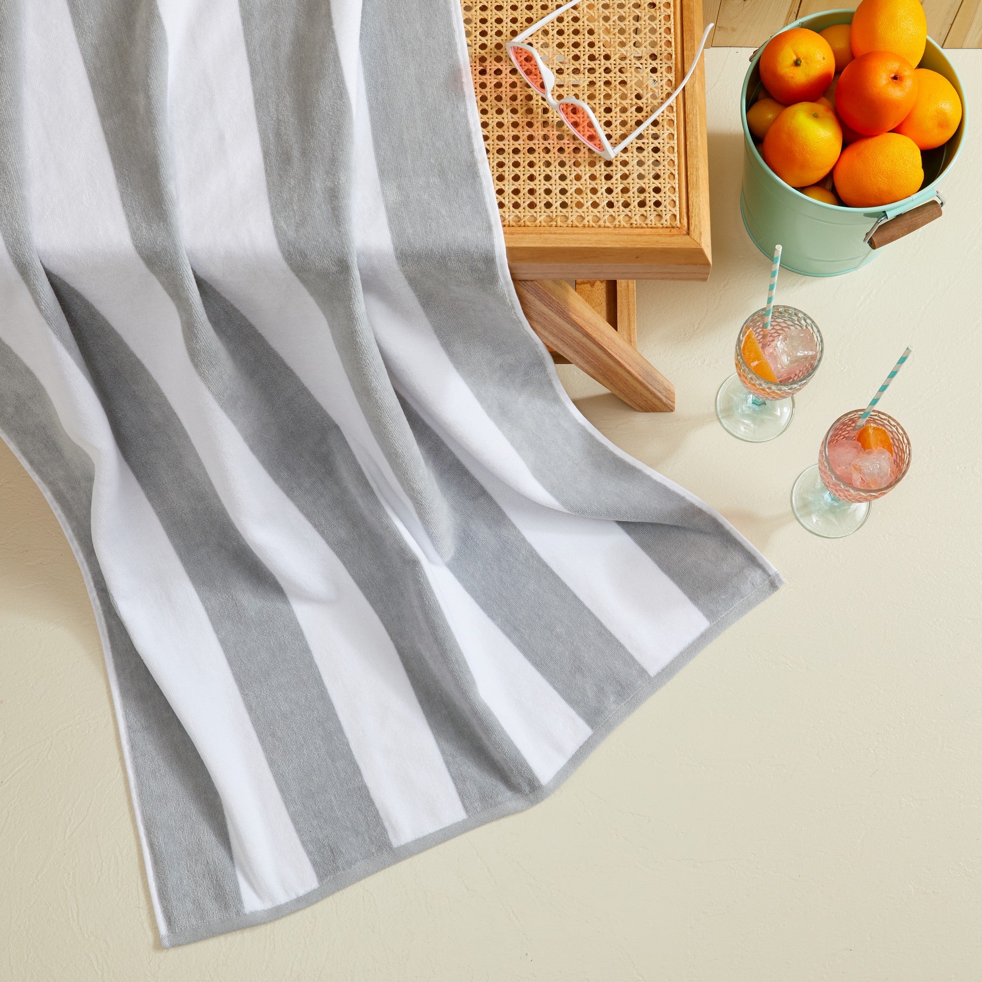 Marina Collection cotton cabana stripe beach towels in assorted colors and sizes, featuring classic striped designs and soft, absorbent 100% cotton velour construction, shown folded, stacked, and styled for poolside and beach use.
