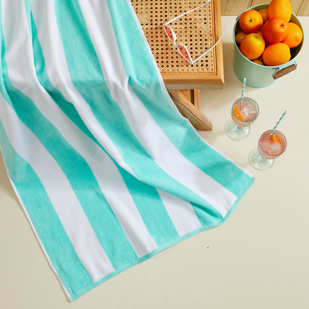 Marina Collection cotton cabana stripe beach towels in assorted colors and sizes, featuring classic striped designs and soft, absorbent 100% cotton velour construction, shown folded, stacked, and styled for poolside and beach use.
