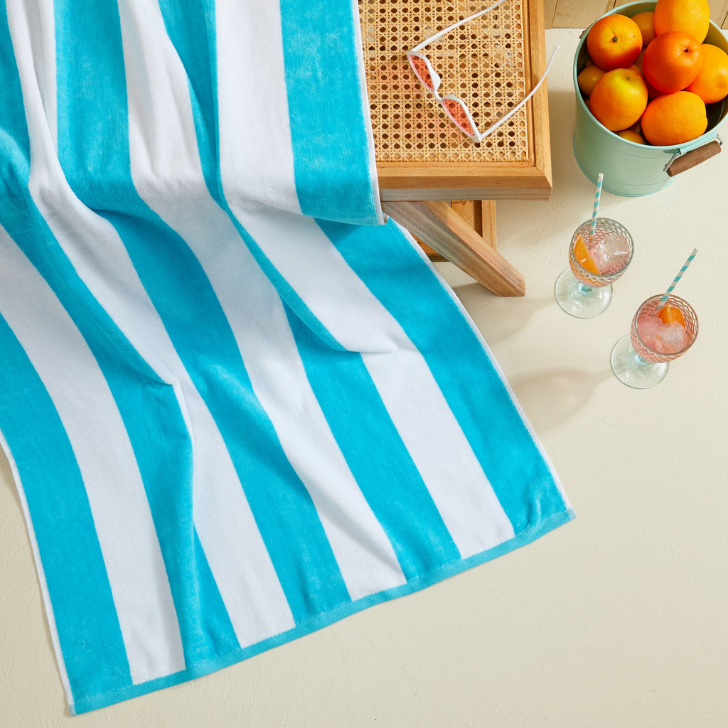 Marina Collection cotton cabana stripe beach towels in assorted colors and sizes, featuring classic striped designs and soft, absorbent 100% cotton velour construction, shown folded, stacked, and styled for poolside and beach use.