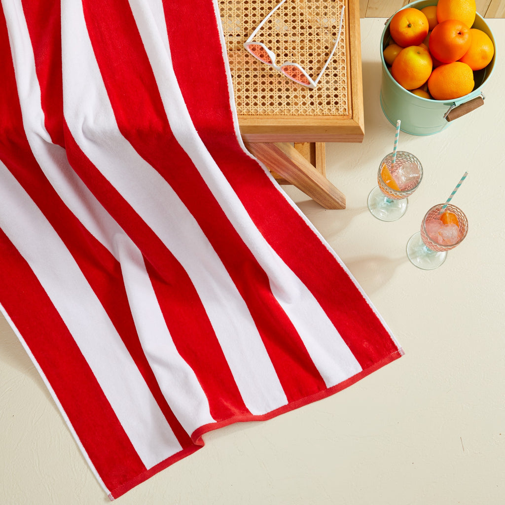 Marina Collection cotton cabana stripe beach towels in assorted colors and sizes, featuring classic striped designs and soft, absorbent 100% cotton velour construction, shown folded, stacked, and styled for poolside and beach use.