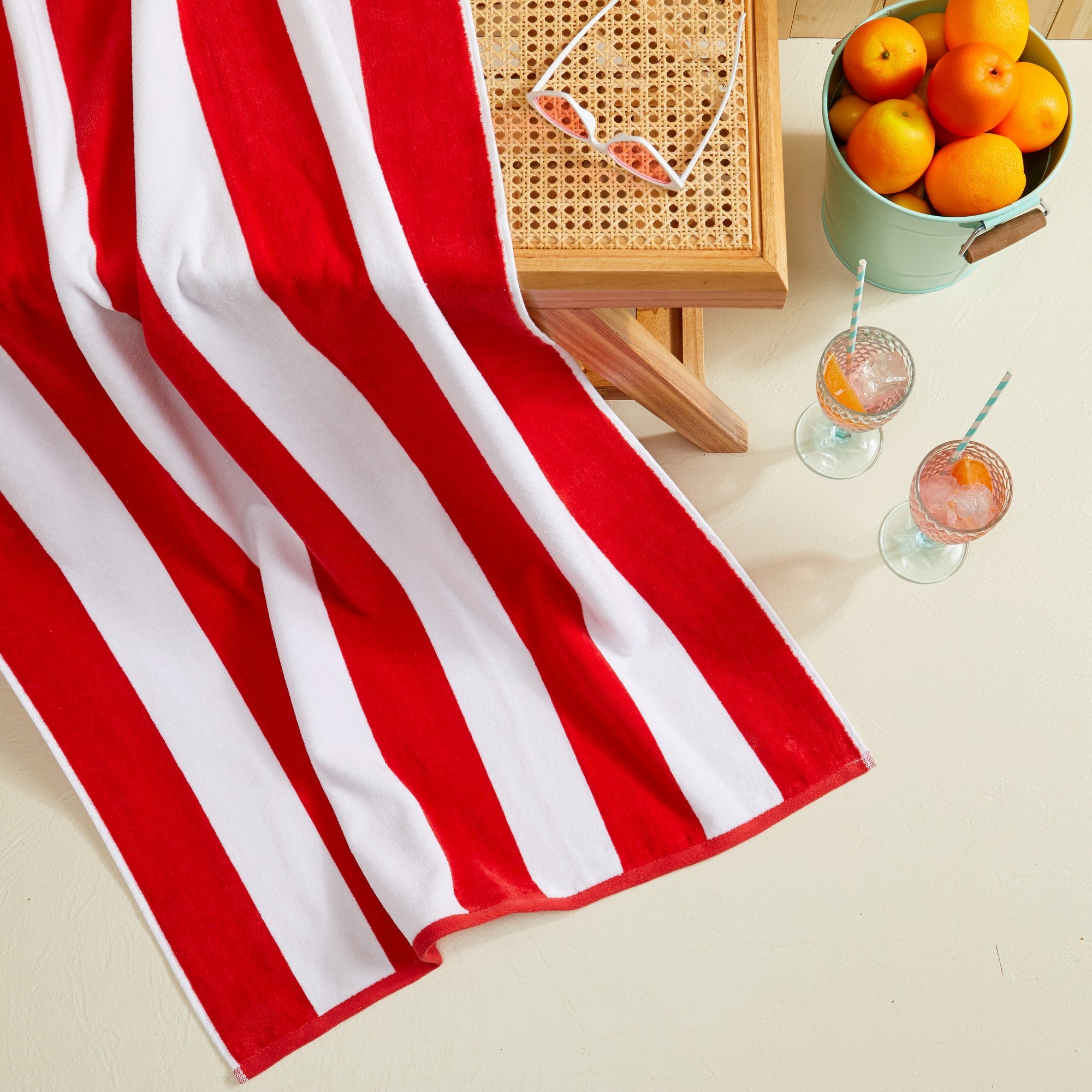 Marina Collection cotton cabana stripe beach towels in assorted colors and sizes, featuring classic striped designs and soft, absorbent 100% cotton velour construction, shown folded, stacked, and styled for poolside and beach use.