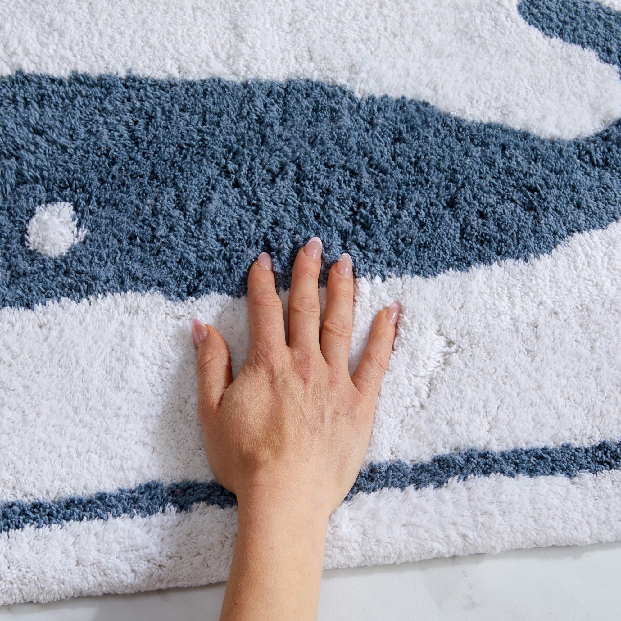 Plush tufted cotton bath rug featuring a fun decorative design with raised detailing. Soft, highly absorbent, and quick-drying, this 20 x 30 inch rug adds comfort and personality to any bathroom. Machine washable for easy care.