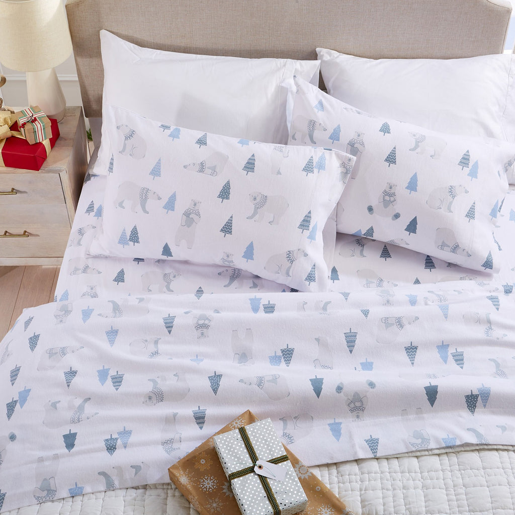Printed 100% Turkish cotton flannel sheet set featuring assorted winter-inspired patterns, including woodland animals, snowflakes, trees, plaids, and seasonal motifs. Soft, cozy bedding shown in styled bedroom settings with close-up fabric details and folded sheet stacks in multiple designs.