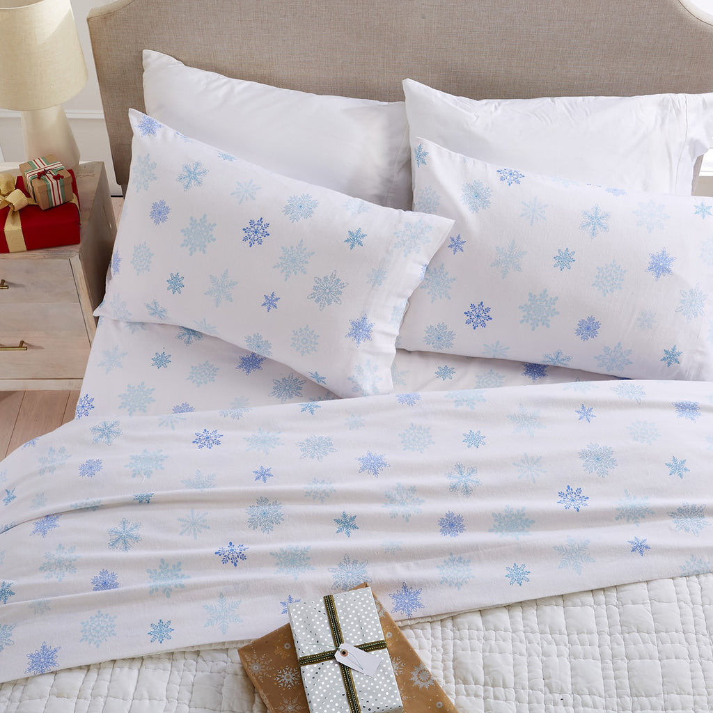 Printed 100% Turkish cotton flannel sheet set featuring assorted winter-inspired patterns, including woodland animals, snowflakes, trees, plaids, and seasonal motifs. Soft, cozy bedding shown in styled bedroom settings with close-up fabric details and folded sheet stacks in multiple designs.