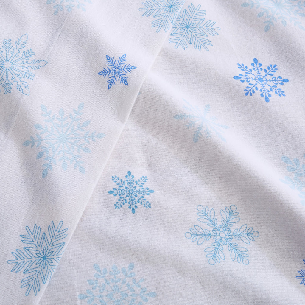 Printed 100% Turkish cotton flannel sheet set featuring assorted winter-inspired patterns, including woodland animals, snowflakes, trees, plaids, and seasonal motifs. Soft, cozy bedding shown in styled bedroom settings with close-up fabric details and folded sheet stacks in multiple designs.