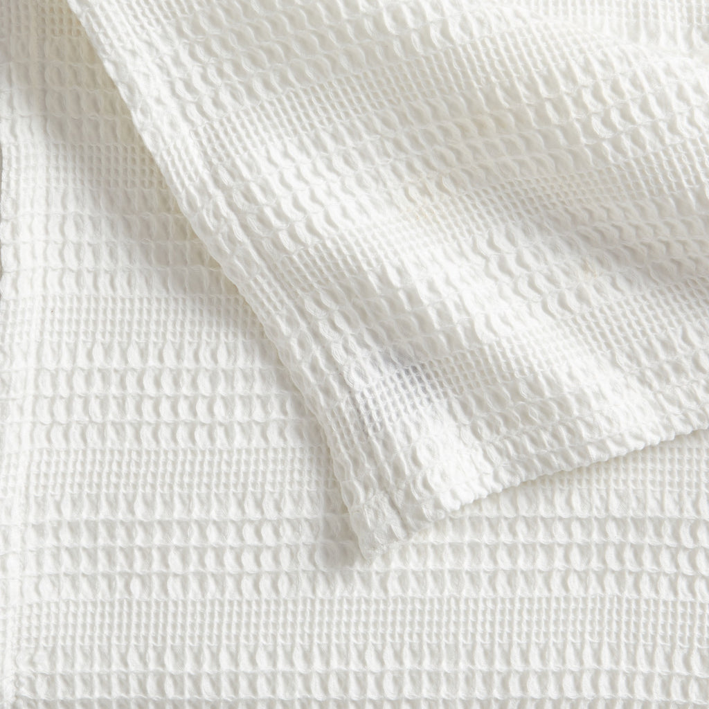 Soft and breathable 100% cotton waffle weave blanket, shown layered on a bed or folded for display. Lightweight and versatile, this textured blanket adds casual comfort and timeless style to any bedroom or living space. Available in Full/Queen and King sizes.