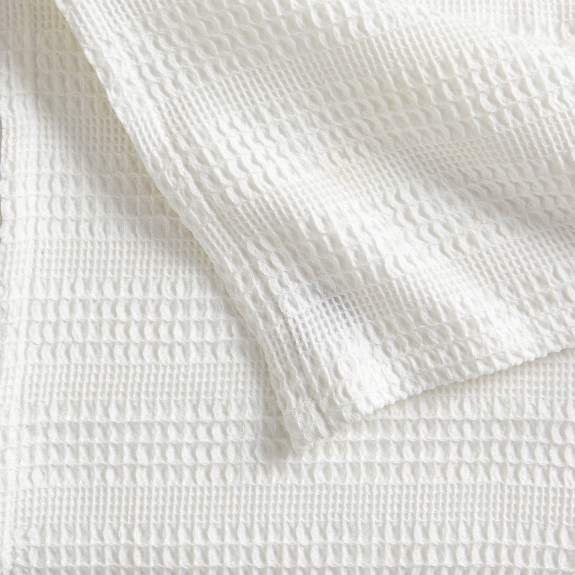 Soft and breathable 100% cotton waffle weave blanket, shown layered on a bed or folded for display. Lightweight and versatile, this textured blanket adds casual comfort and timeless style to any bedroom or living space. Available in Full/Queen and King sizes.