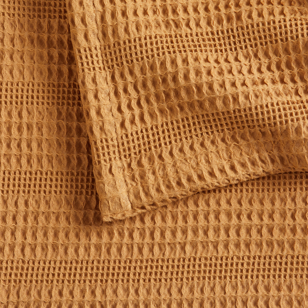 Soft and breathable 100% cotton waffle weave blanket, shown layered on a bed or folded for display. Lightweight and versatile, this textured blanket adds casual comfort and timeless style to any bedroom or living space. Available in Full/Queen and King sizes.