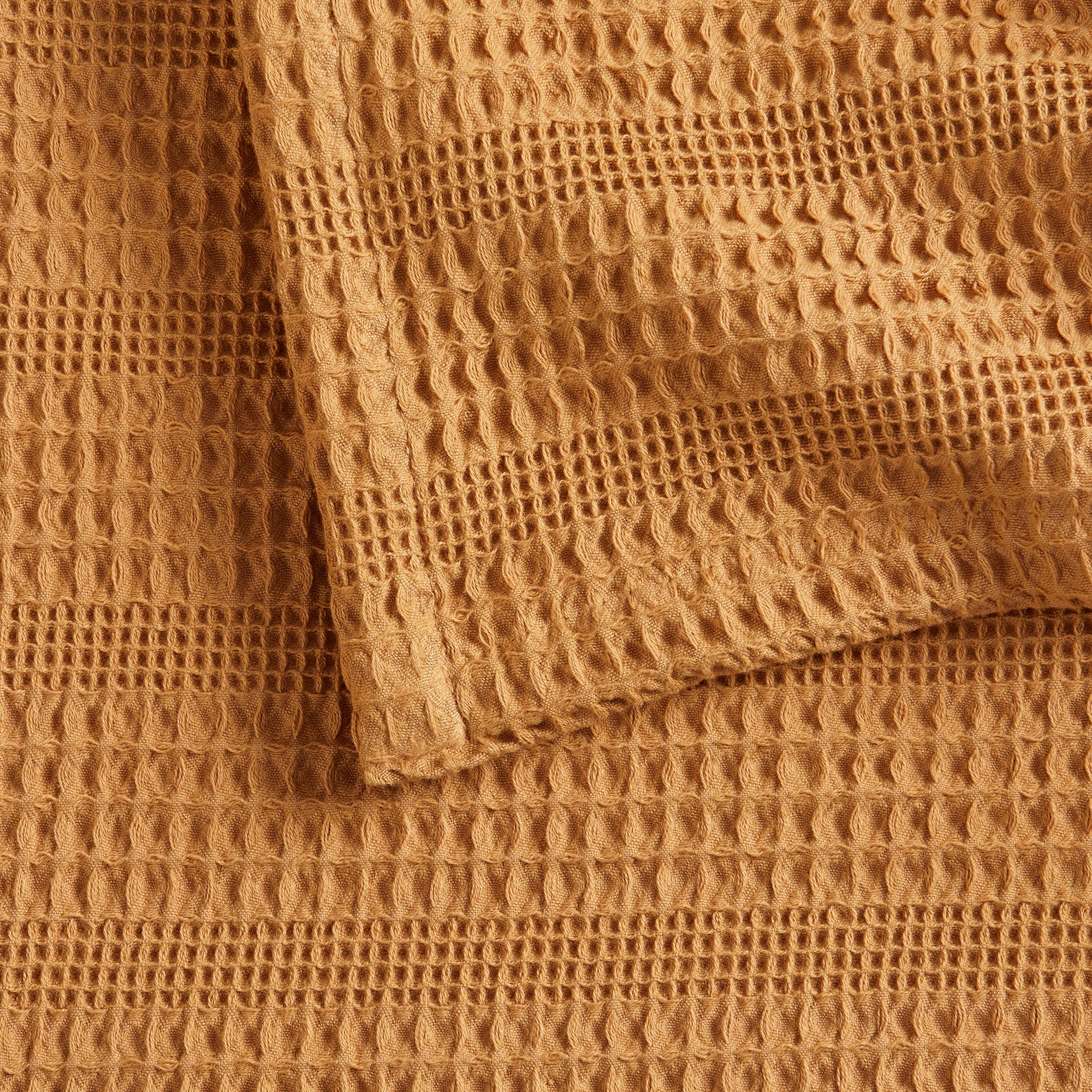 Soft and breathable 100% cotton waffle weave blanket, shown layered on a bed or folded for display. Lightweight and versatile, this textured blanket adds casual comfort and timeless style to any bedroom or living space. Available in Full/Queen and King sizes.