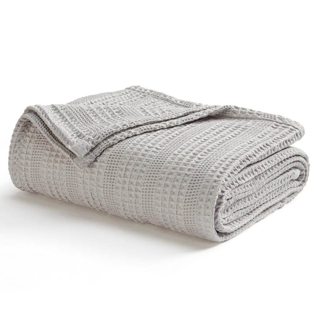 Soft and breathable 100% cotton waffle weave blanket, shown layered on a bed or folded for display. Lightweight and versatile, this textured blanket adds casual comfort and timeless style to any bedroom or living space. Available in Full/Queen and King sizes.