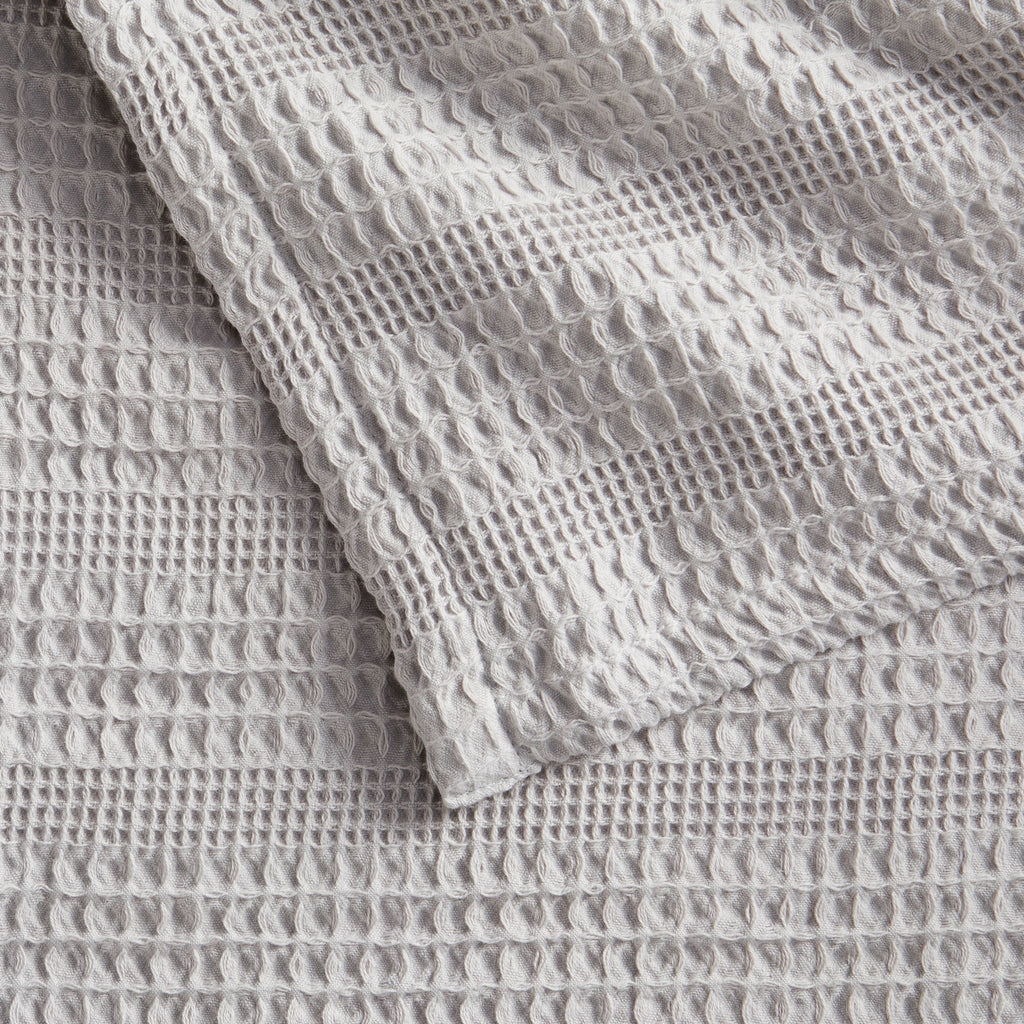 Soft and breathable 100% cotton waffle weave blanket, shown layered on a bed or folded for display. Lightweight and versatile, this textured blanket adds casual comfort and timeless style to any bedroom or living space. Available in Full/Queen and King sizes.