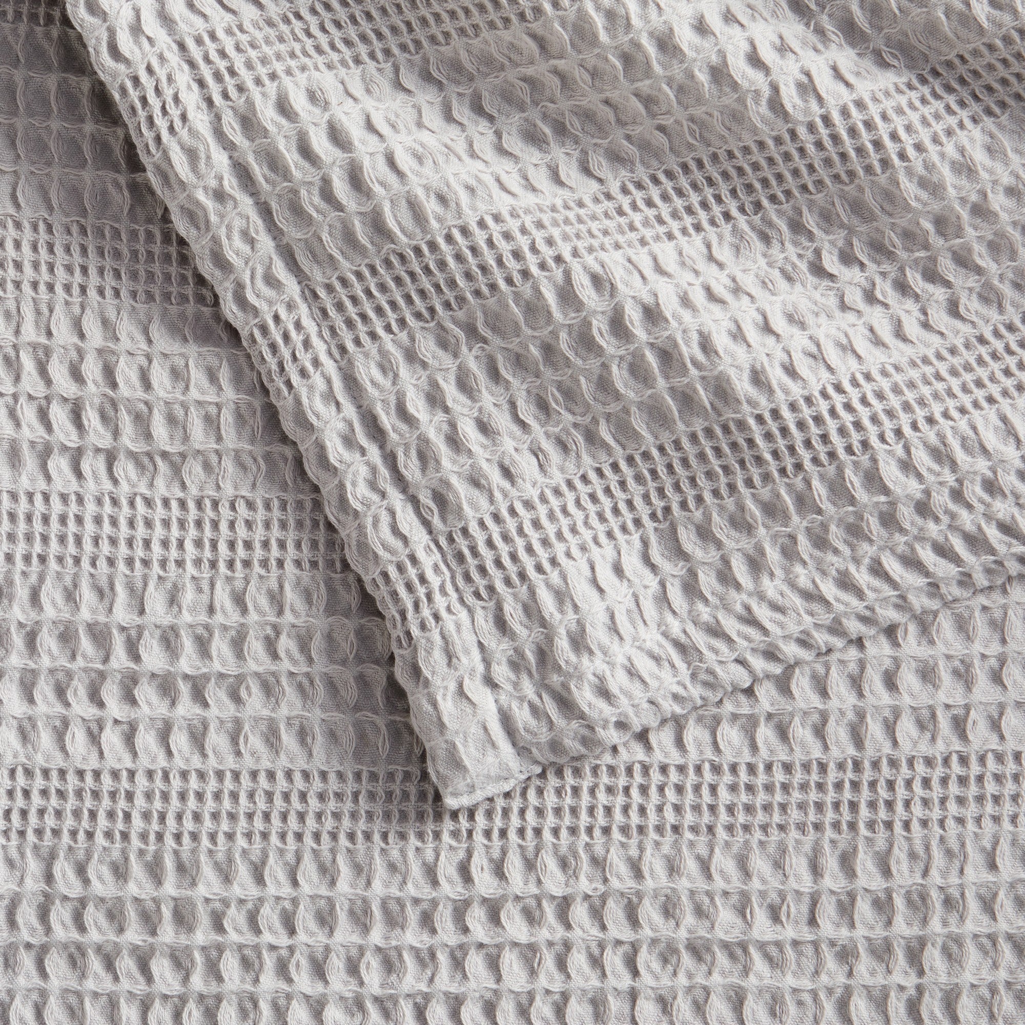 Soft and breathable 100% cotton waffle weave blanket, shown layered on a bed or folded for display. Lightweight and versatile, this textured blanket adds casual comfort and timeless style to any bedroom or living space. Available in Full/Queen and King sizes.