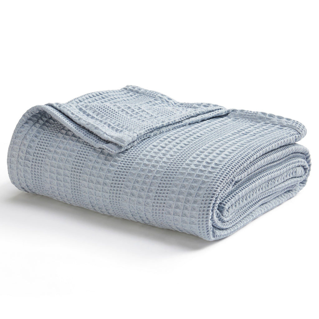 Soft and breathable 100% cotton waffle weave blanket, shown layered on a bed or folded for display. Lightweight and versatile, this textured blanket adds casual comfort and timeless style to any bedroom or living space. Available in Full/Queen and King sizes.