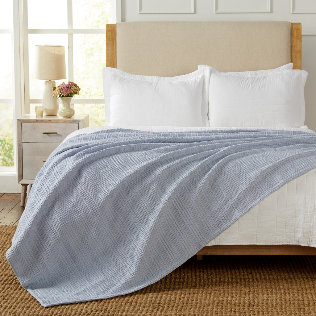 Soft and breathable 100% cotton waffle weave blanket, shown layered on a bed or folded for display. Lightweight and versatile, this textured blanket adds casual comfort and timeless style to any bedroom or living space. Available in Full/Queen and King sizes.