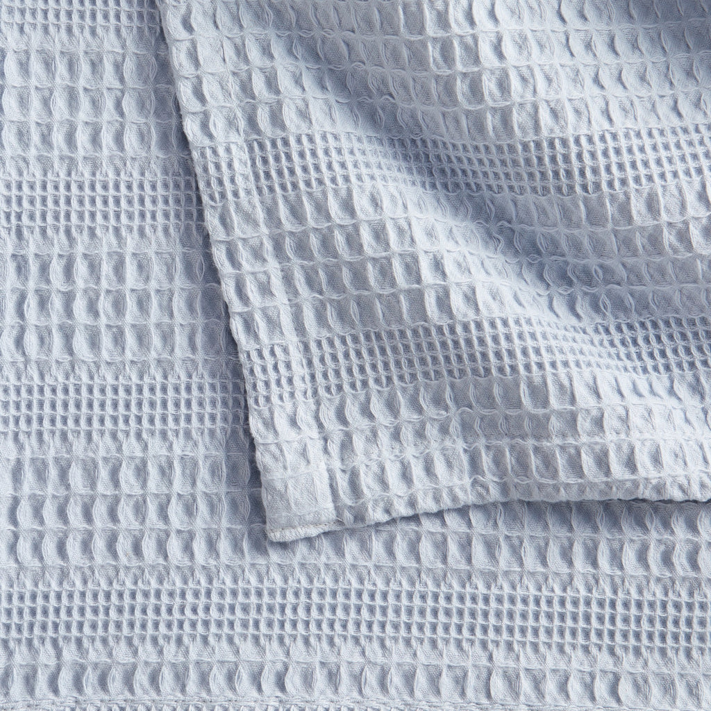 Soft and breathable 100% cotton waffle weave blanket, shown layered on a bed or folded for display. Lightweight and versatile, this textured blanket adds casual comfort and timeless style to any bedroom or living space. Available in Full/Queen and King sizes.