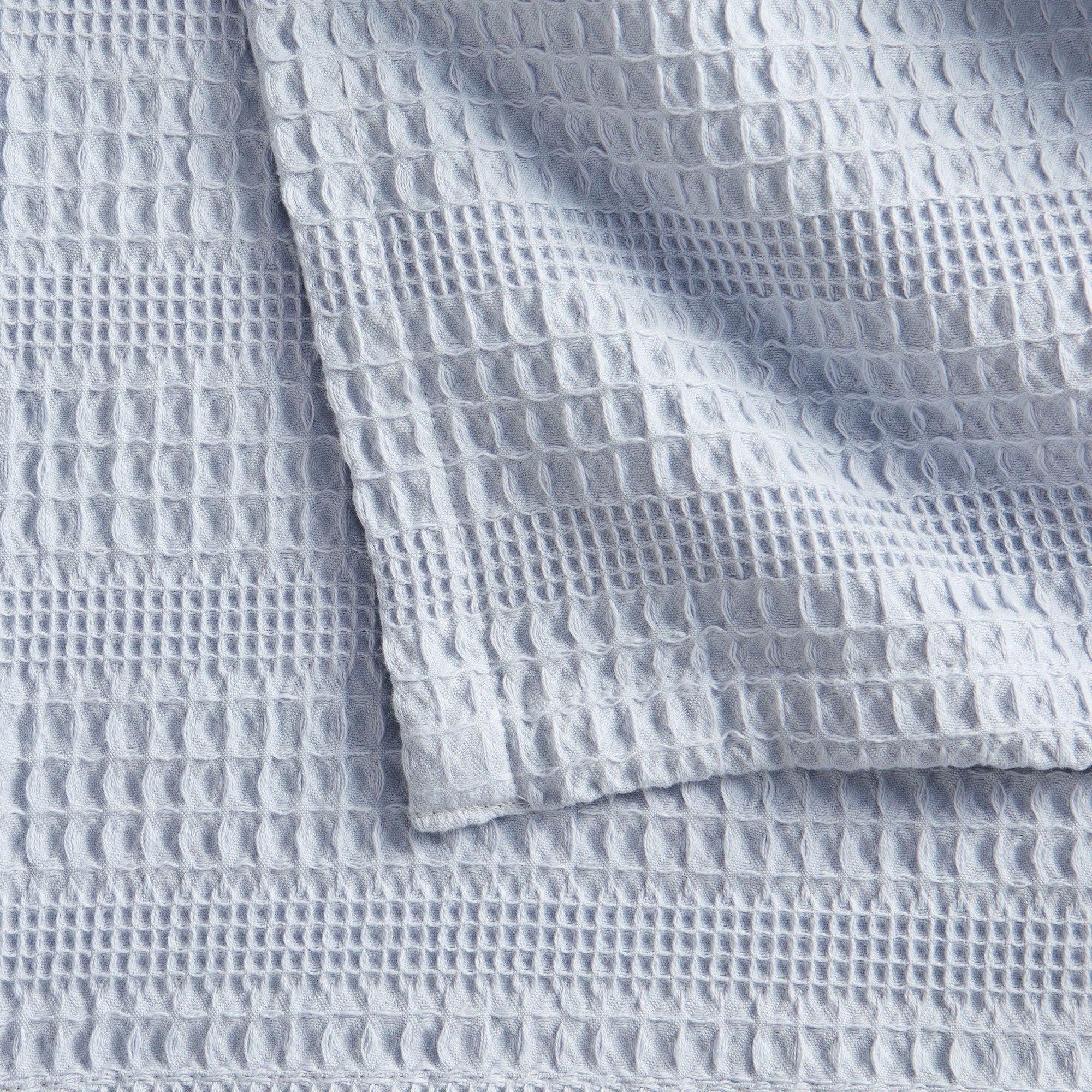 Soft and breathable 100% cotton waffle weave blanket, shown layered on a bed or folded for display. Lightweight and versatile, this textured blanket adds casual comfort and timeless style to any bedroom or living space. Available in Full/Queen and King sizes.