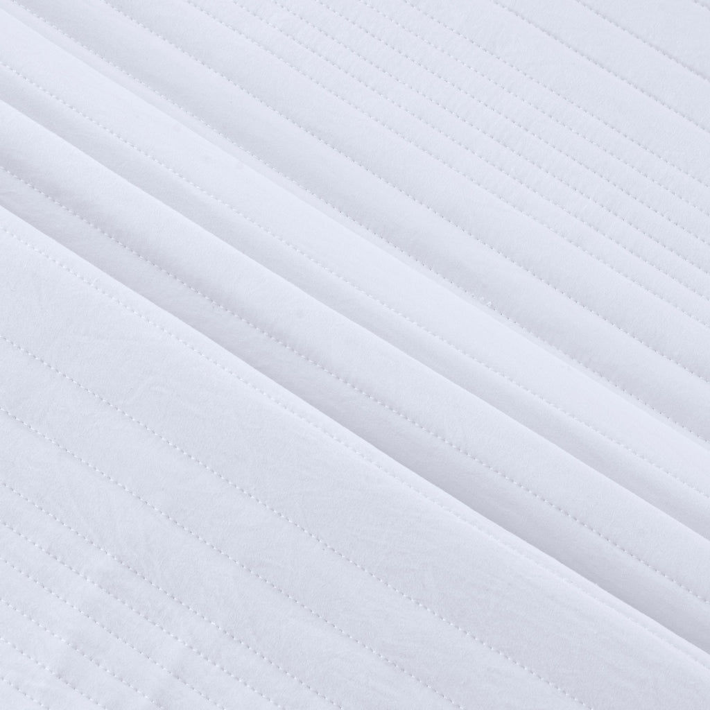 Parker Collection Solid Embroidered Quilt Set by Market & Place featuring soft microfiber construction and elegant channel embroidery. Available in multiple colors with coordinating shams and detailed fabric close-ups, styled in a modern bedroom setting.