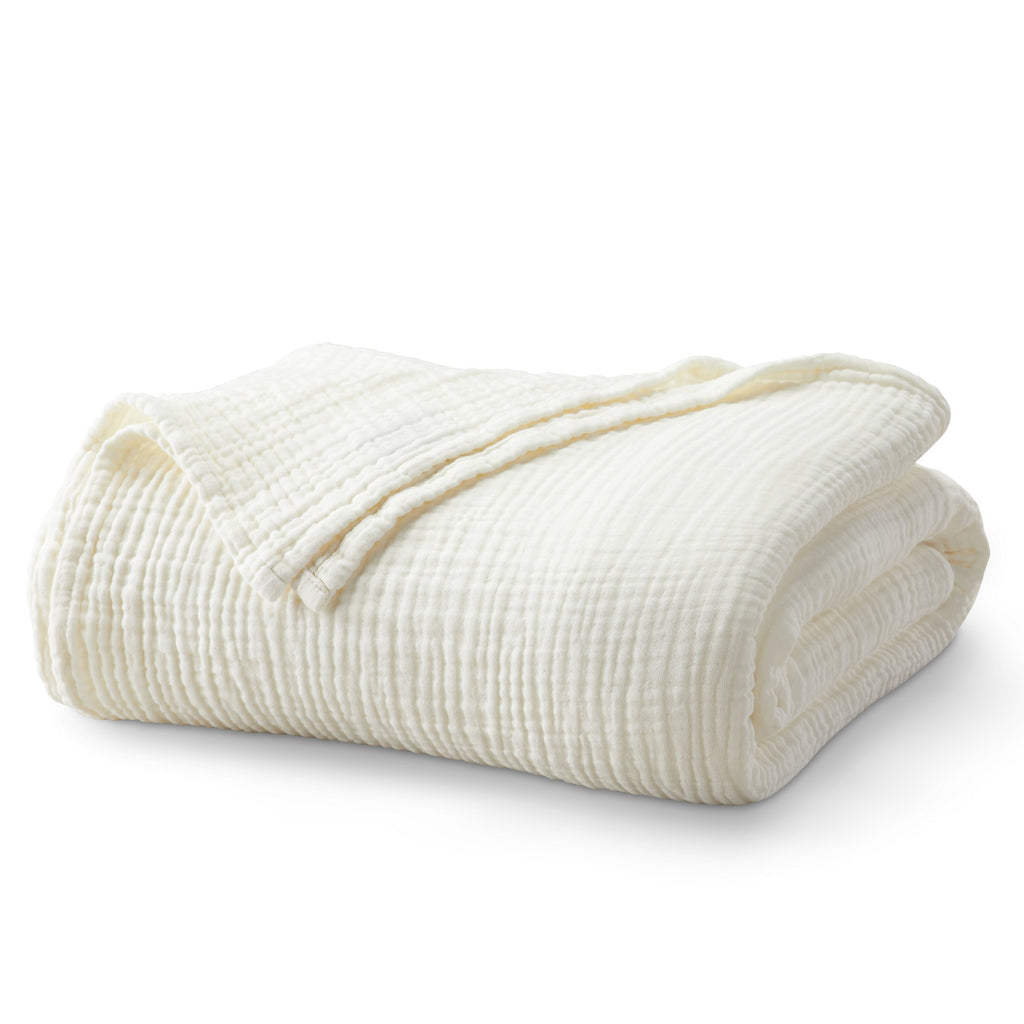 Folded Off-White Maria Collection cotton muslin blanket, featuring a soft textured muslin weave and lightweight construction, neatly displayed to showcase its cozy, breathable design.