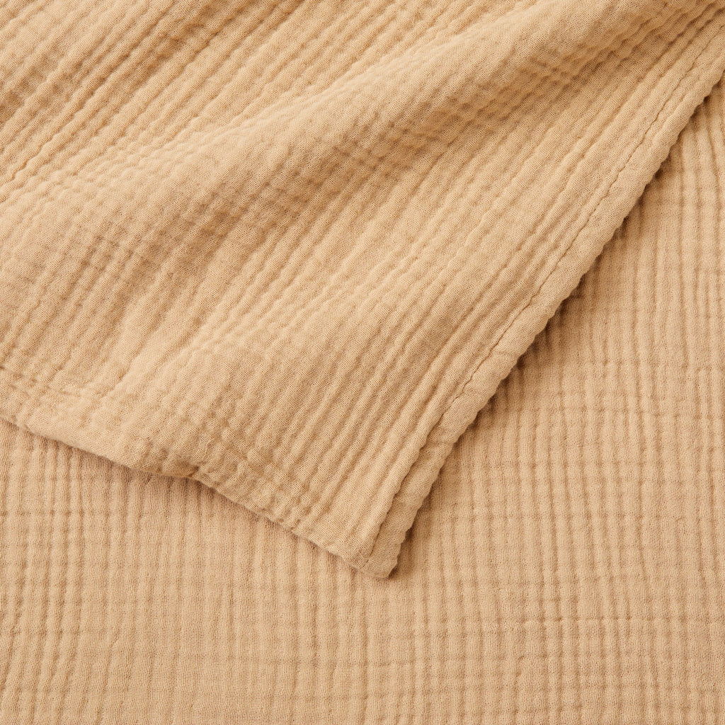 Close-up detail of the Beige Maria Collection cotton muslin blanket showcasing its soft gauze texture, breathable multi-layer weave, and relaxed natural appearance. The image highlights the blanket’s lightweight construction and casual, cozy feel.