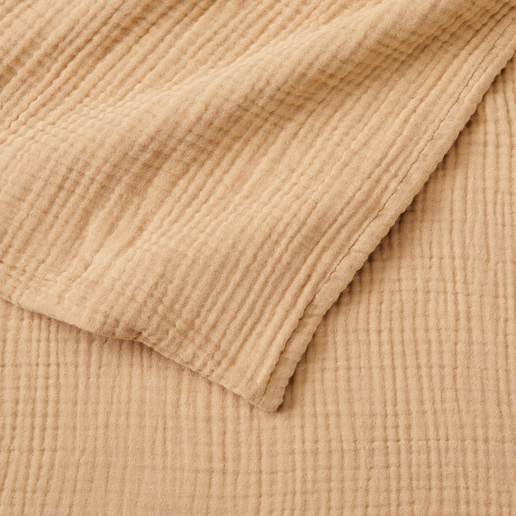 Close-up detail of the Beige Maria Collection cotton muslin blanket showcasing its soft gauze texture, breathable multi-layer weave, and relaxed natural appearance. The image highlights the blanket’s lightweight construction and casual, cozy feel.