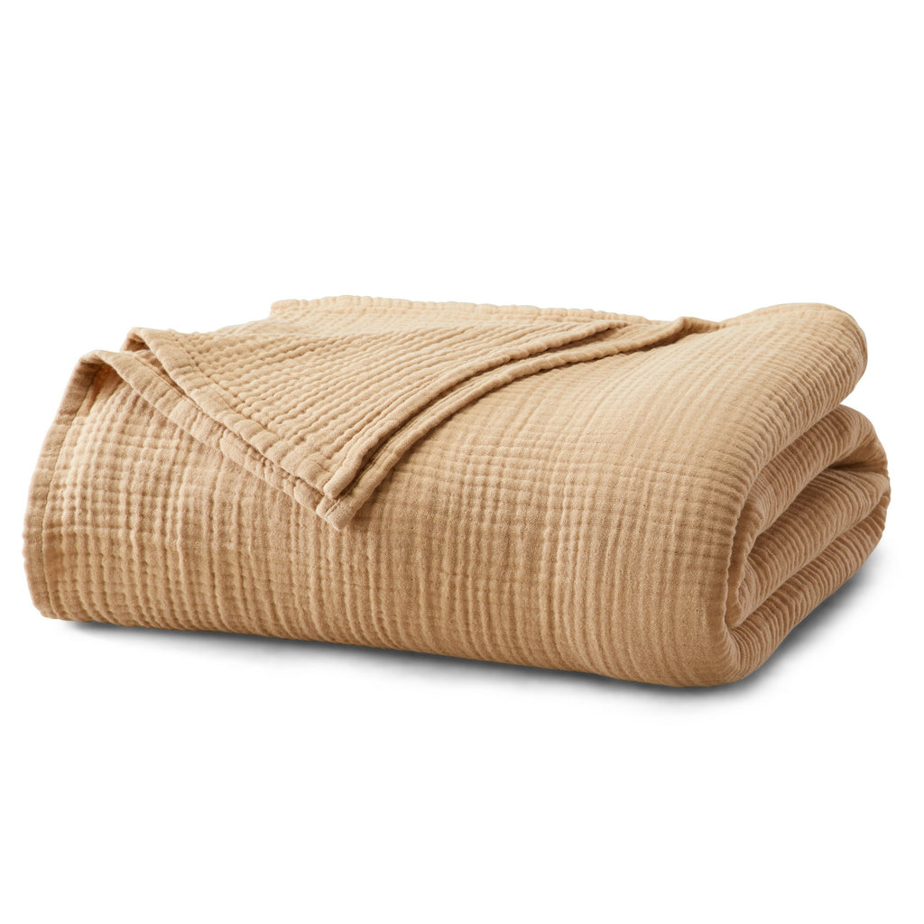 Folded Beige Maria Collection cotton muslin blanket, featuring a soft textured muslin weave and lightweight construction, neatly displayed to highlight its breathable comfort and casual style.