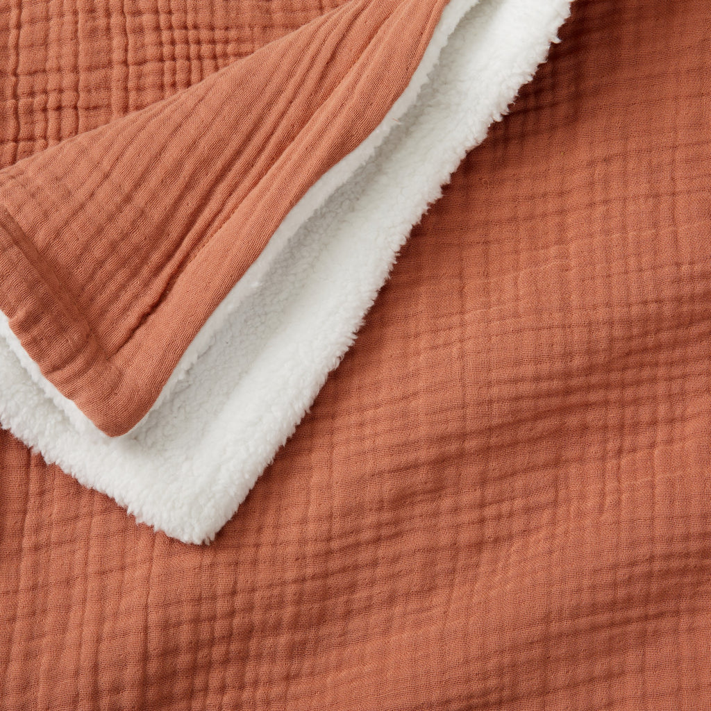 Close-up of the Rust Maria Collection cotton muslin sherpa throw blanket, highlighting the textured cotton muslin face and ultra-soft sherpa backing for cozy, year-round comfort.
