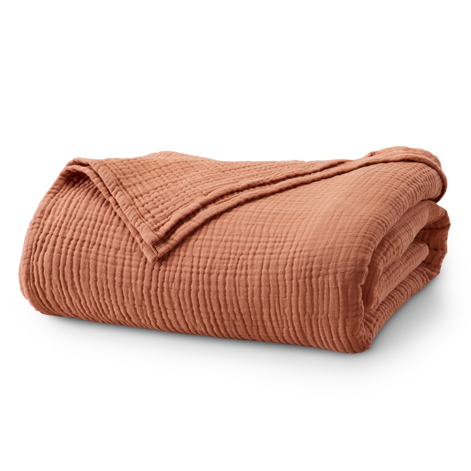 Folded Rust Maria Collection cotton muslin blanket featuring a soft textured muslin weave and warm earthy color, neatly displayed to highlight its breathable comfort, lightweight feel, and casual modern style.