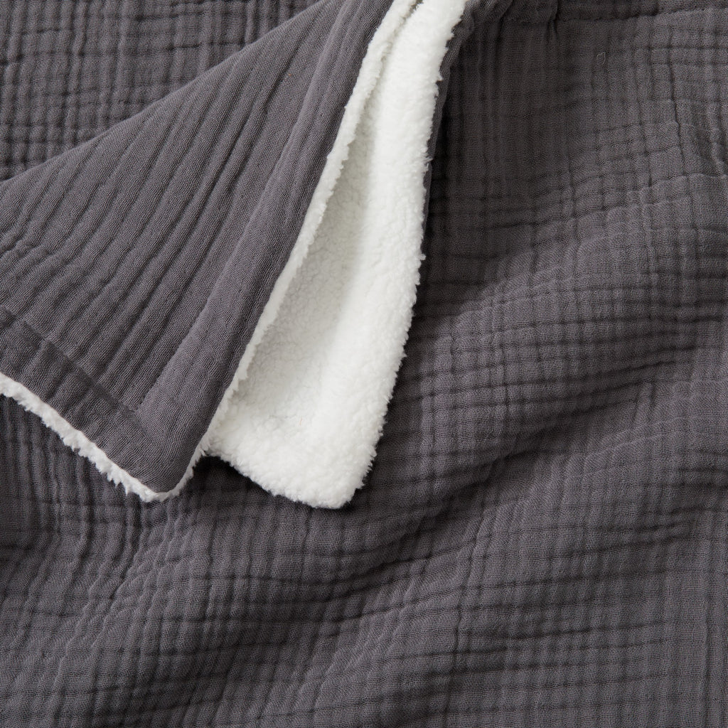 Close-up of the Charcoal Maria Collection cotton muslin sherpa throw blanket, featuring a textured cotton muslin surface with a plush sherpa reverse for exceptional softness and warmth.