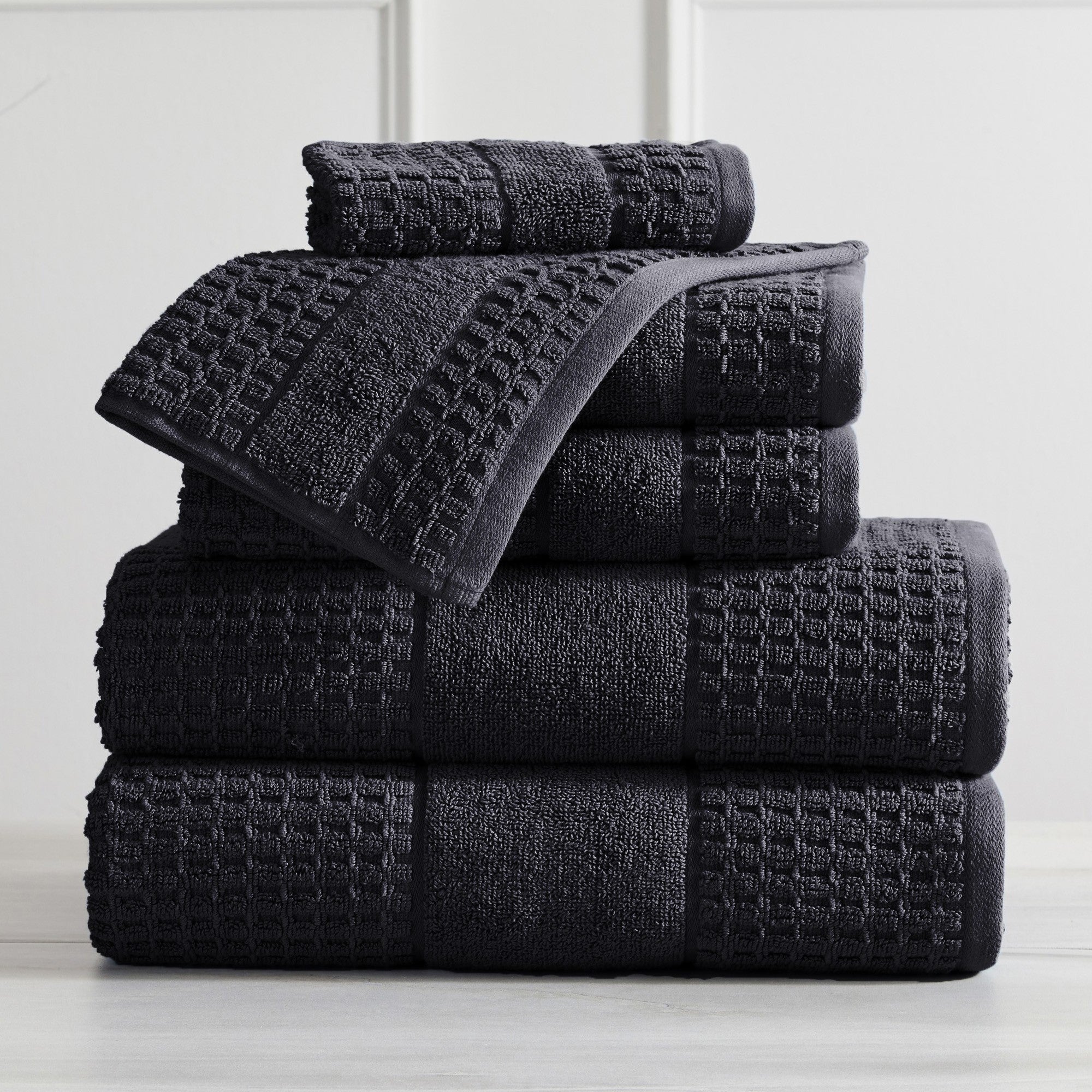 Harper Collection Waffle Textured Bath Towels by Market & Place featuring premium 100% cotton construction with a stylish waffle weave texture. Available in multiple colors and set configurations, including bath towels, hand towels, and washcloths, shown folded, stacked, and styled to highlight their soft, plush, and highly absorbent design.