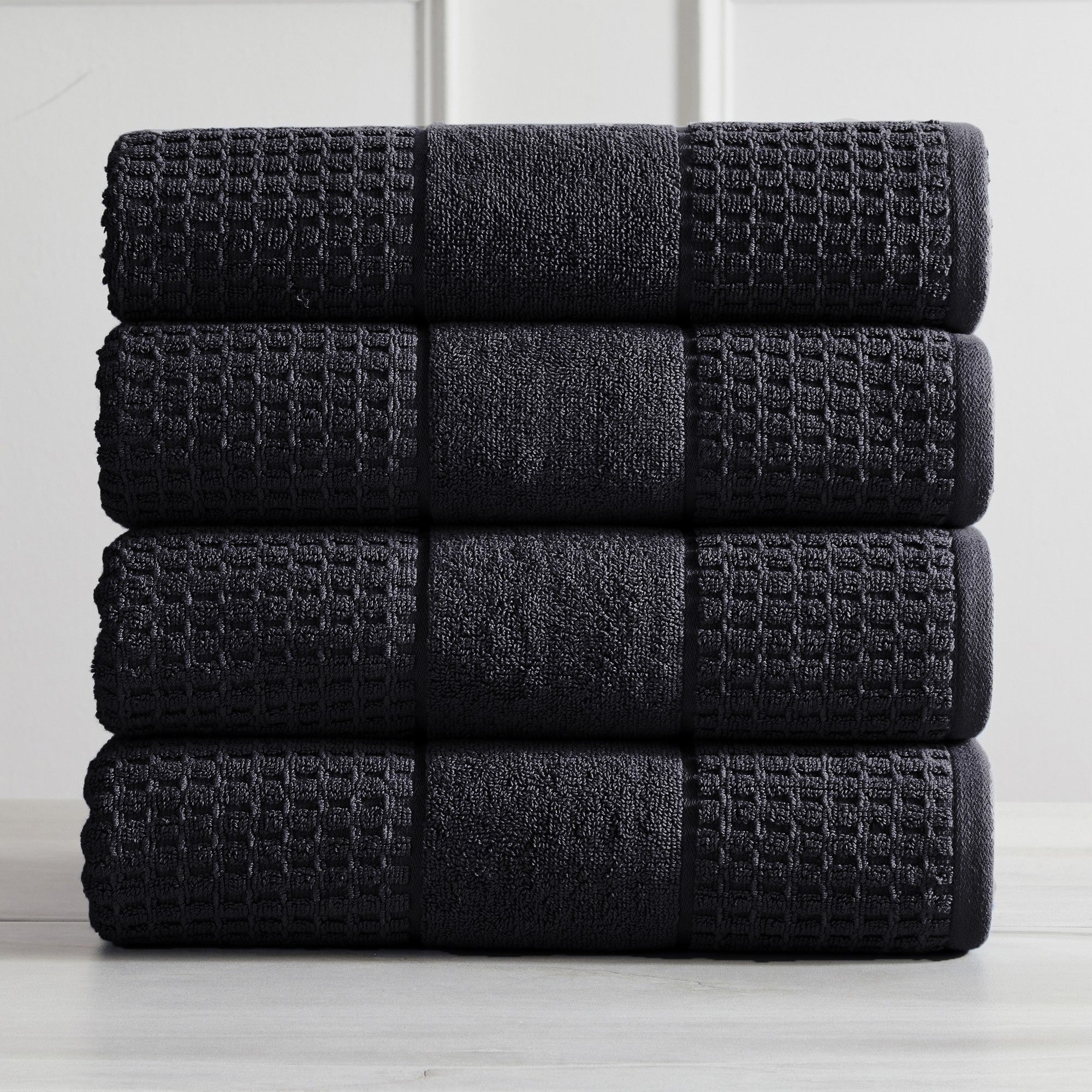 Harper Collection Waffle Textured Bath Towels by Market & Place featuring premium 100% cotton construction with a stylish waffle weave texture. Available in multiple colors and set configurations, including bath towels, hand towels, and washcloths, shown folded, stacked, and styled to highlight their soft, plush, and highly absorbent design.
