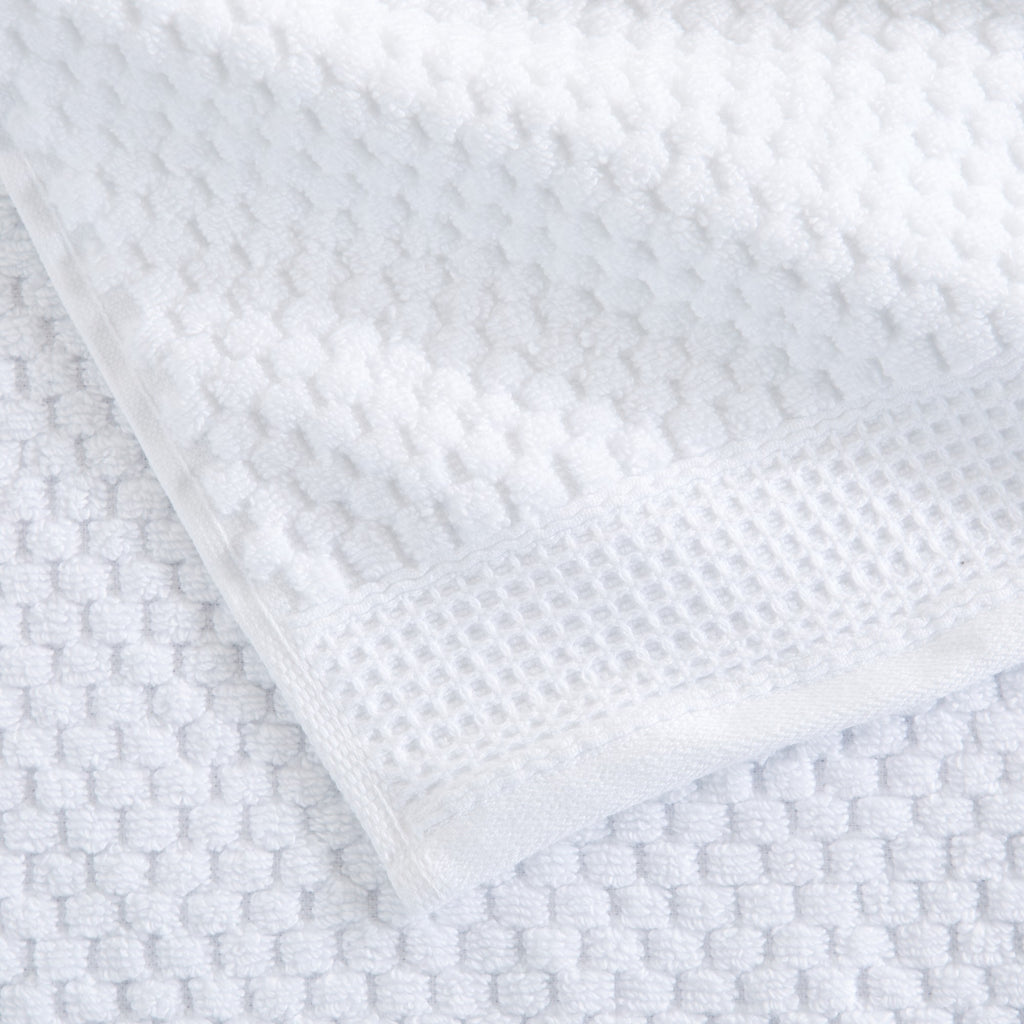 Close-up of white cotton bath towels with textured weave