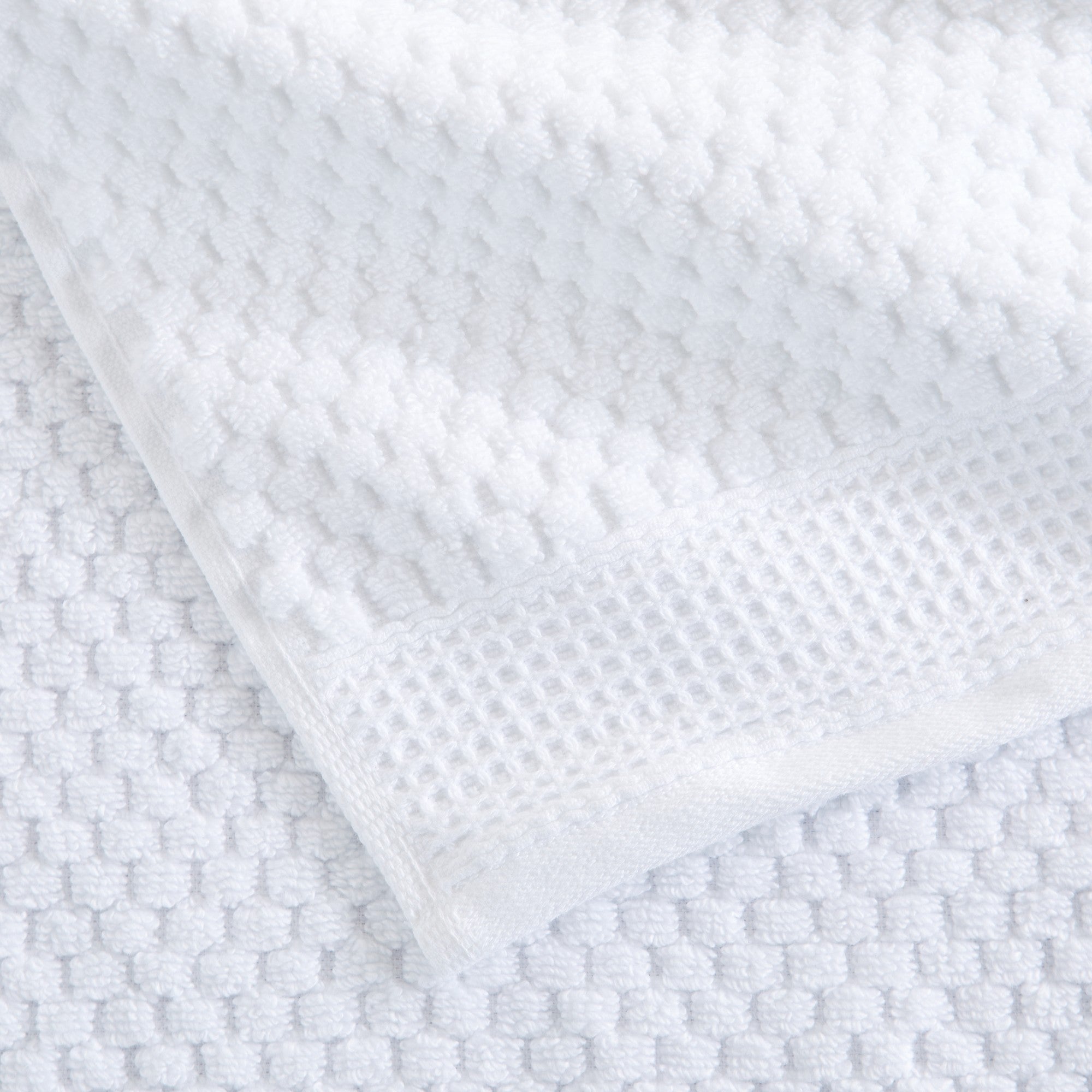 Close-up of white cotton bath towels with textured weave