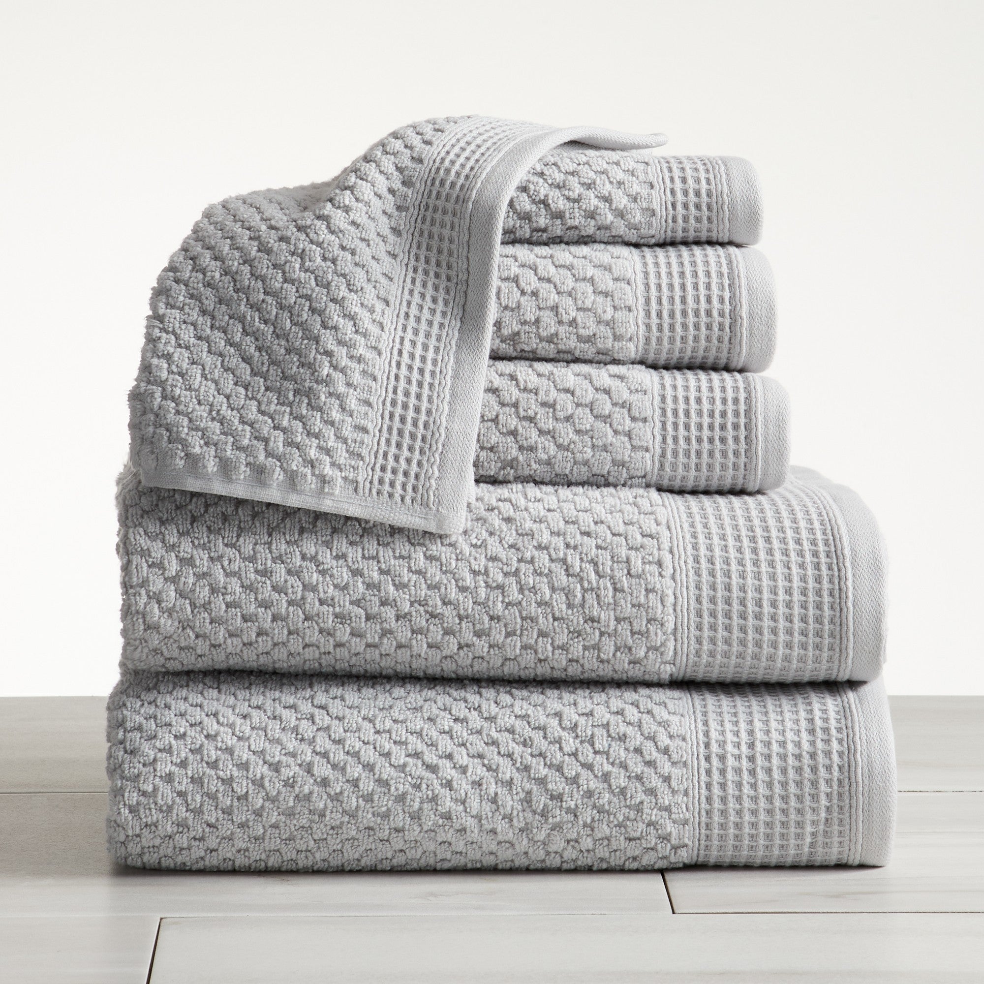 Close-up of light grey cotton bath towels with textured weave