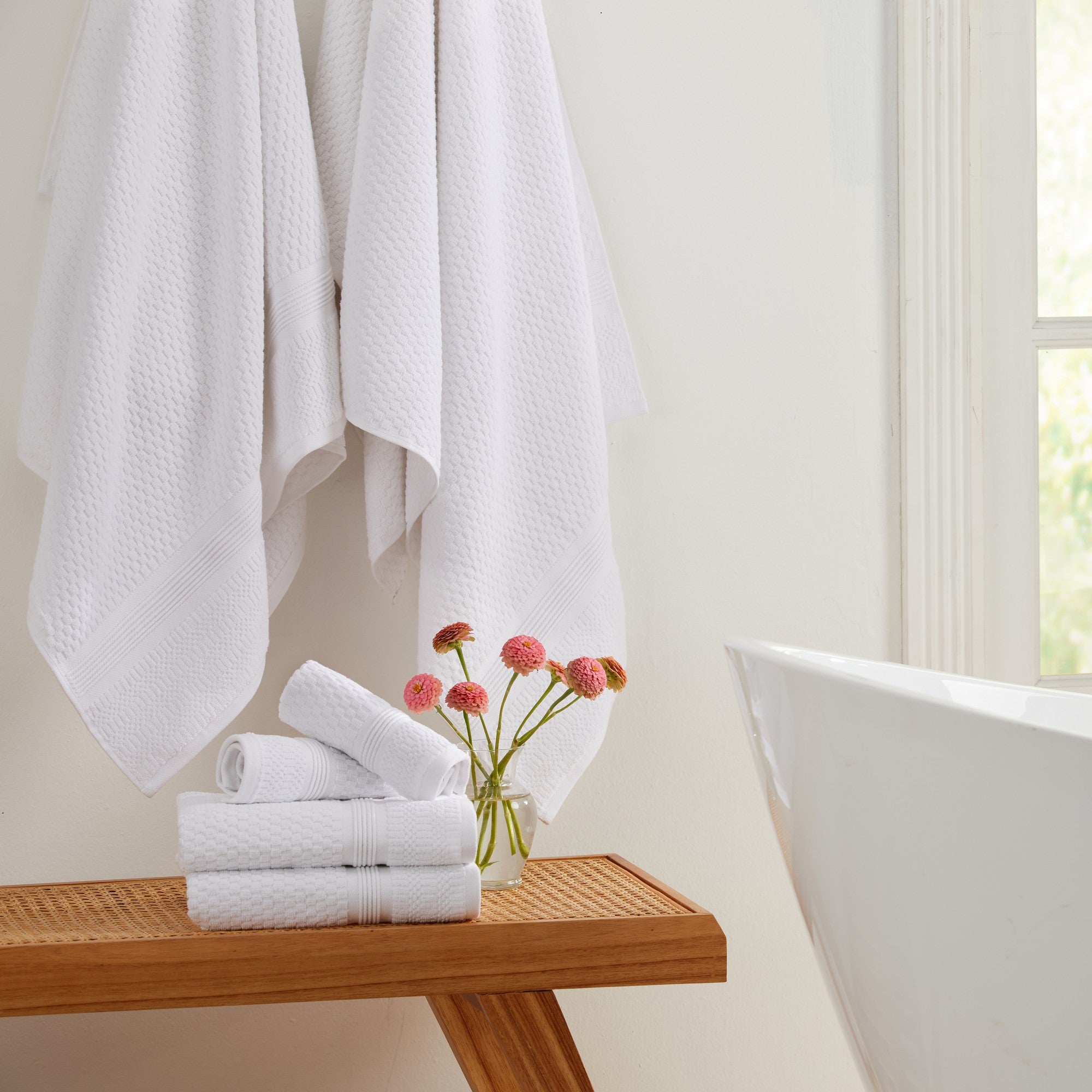White waffle weave cotton bath towels hanging in modern bathroom