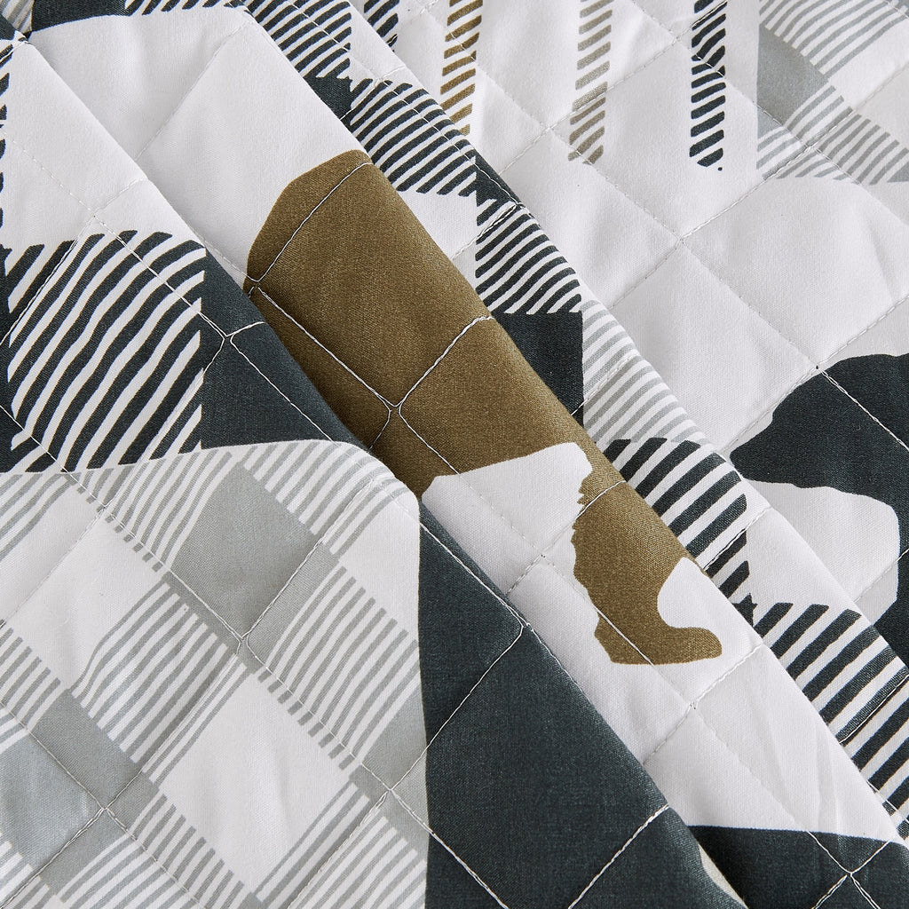 Orson Collection Lodge Quilt Set by Market & Place featuring soft microfiber construction and rustic lodge-inspired patchwork designs with plaid patterns and wildlife motifs. Coordinating shams and detailed fabric close-ups are shown in cozy bedroom settings, highlighting the reversible design and year-round comfort.