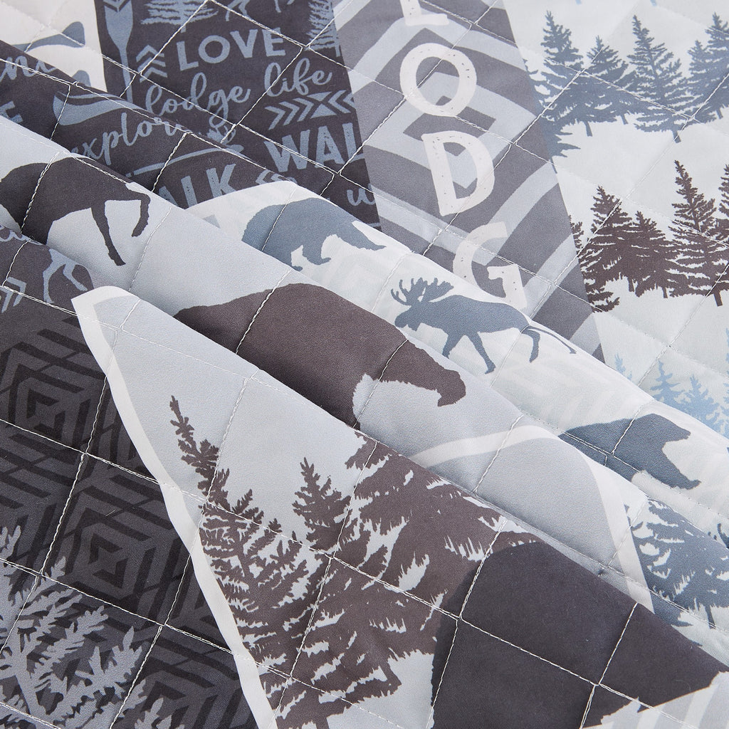Denali Collection reversible lodge quilt set close up featuring moose bear woodland tree cabin patchwork quilted microfiber bedding