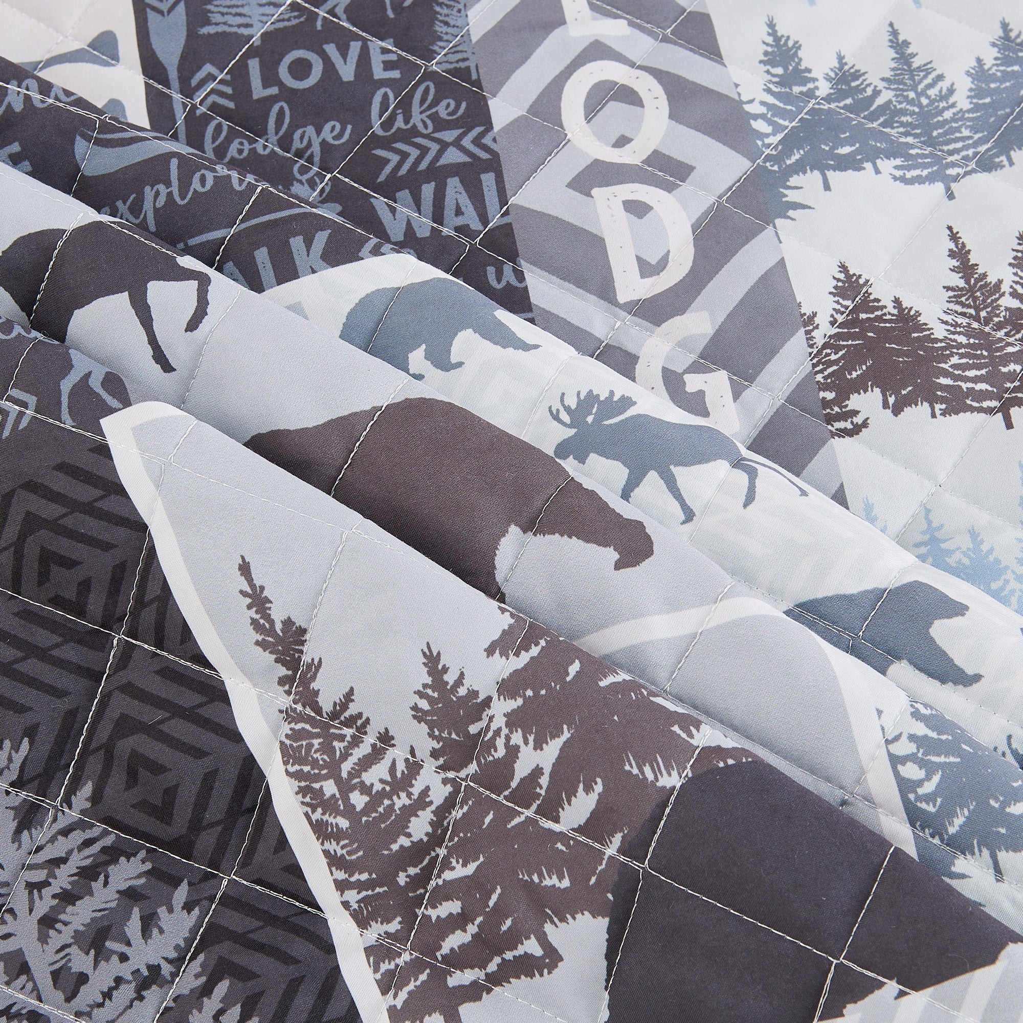 Denali Collection reversible lodge quilt set close up featuring moose bear woodland tree cabin patchwork quilted microfiber bedding