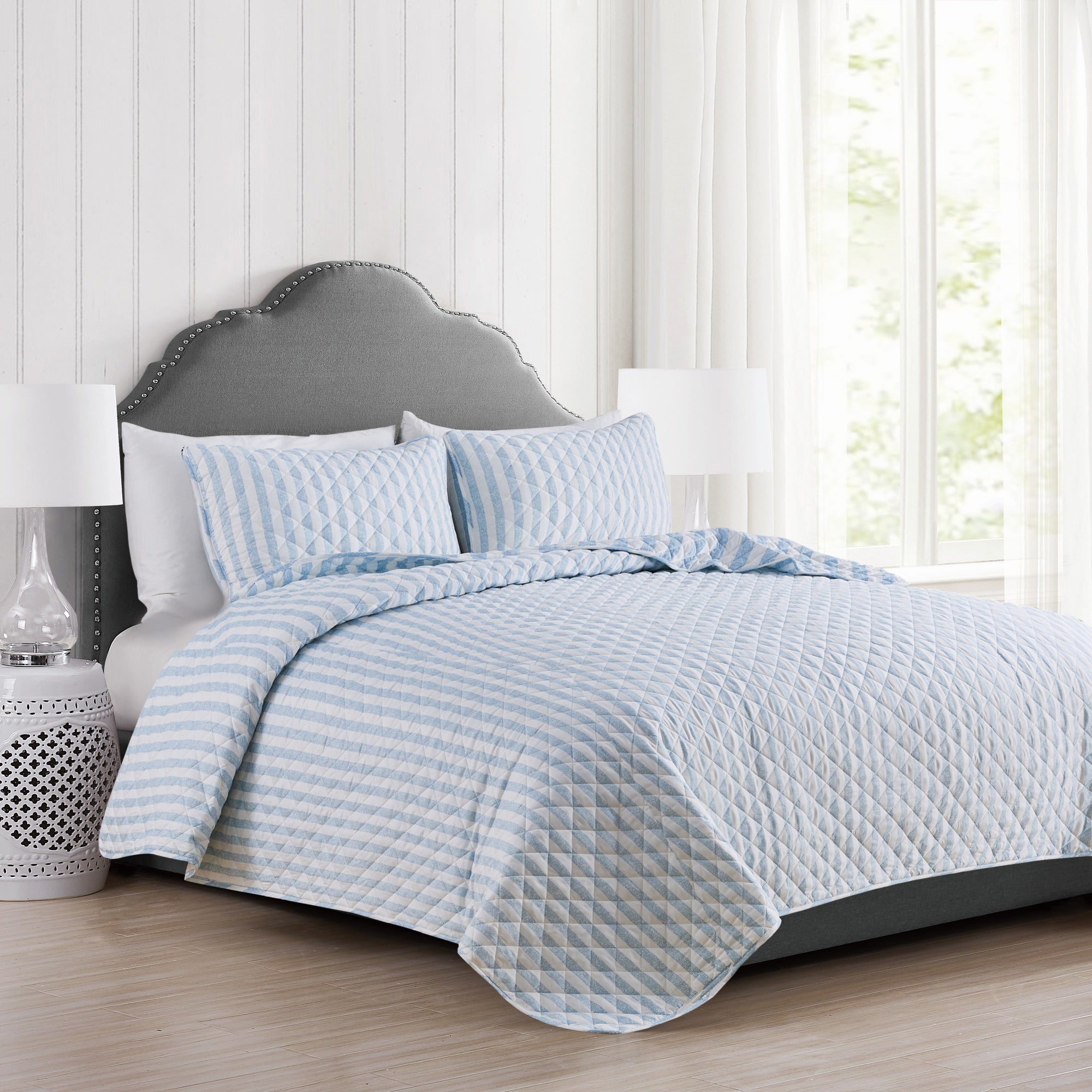 Avery Collection reversible blue and white striped quilt set displayed on a bed with matching pillow shams
