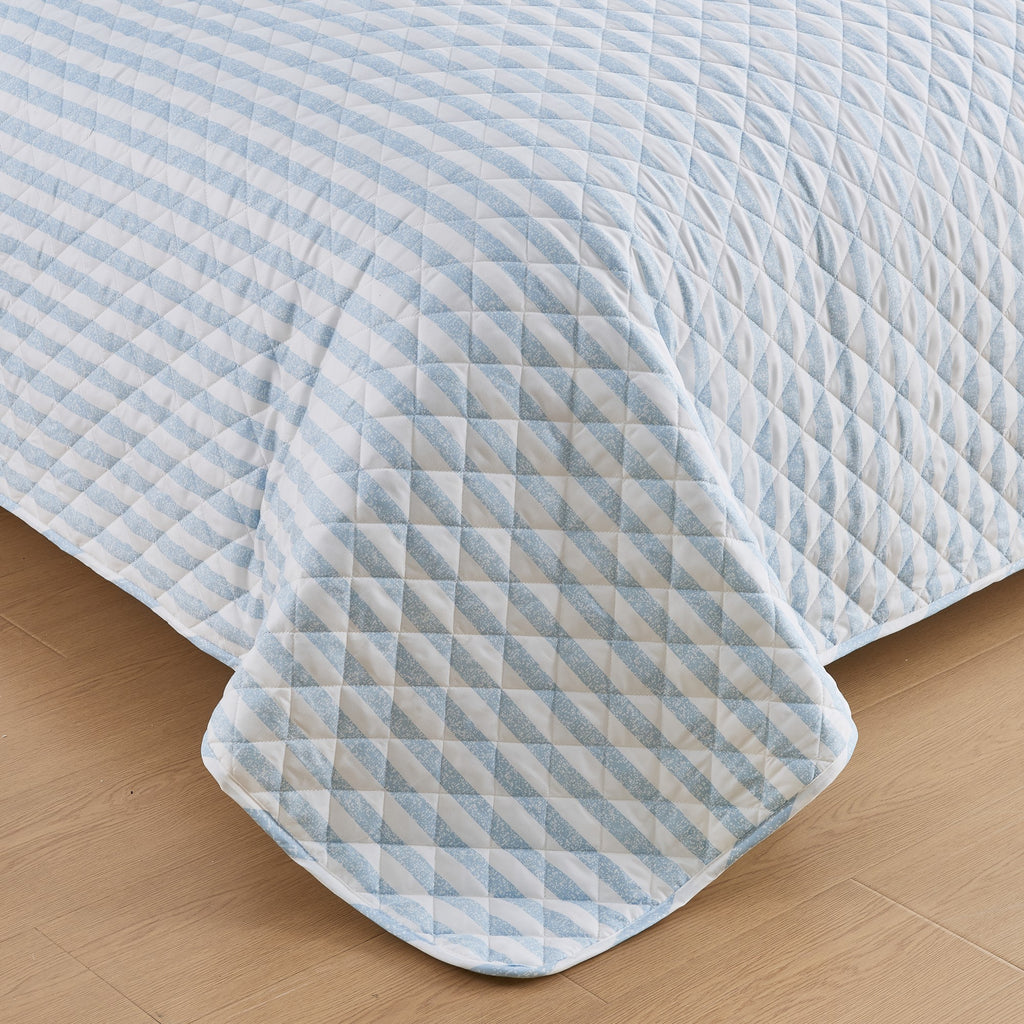 Close-up of Avery Collection blue and white striped quilt featuring diamond stitch quilting detail