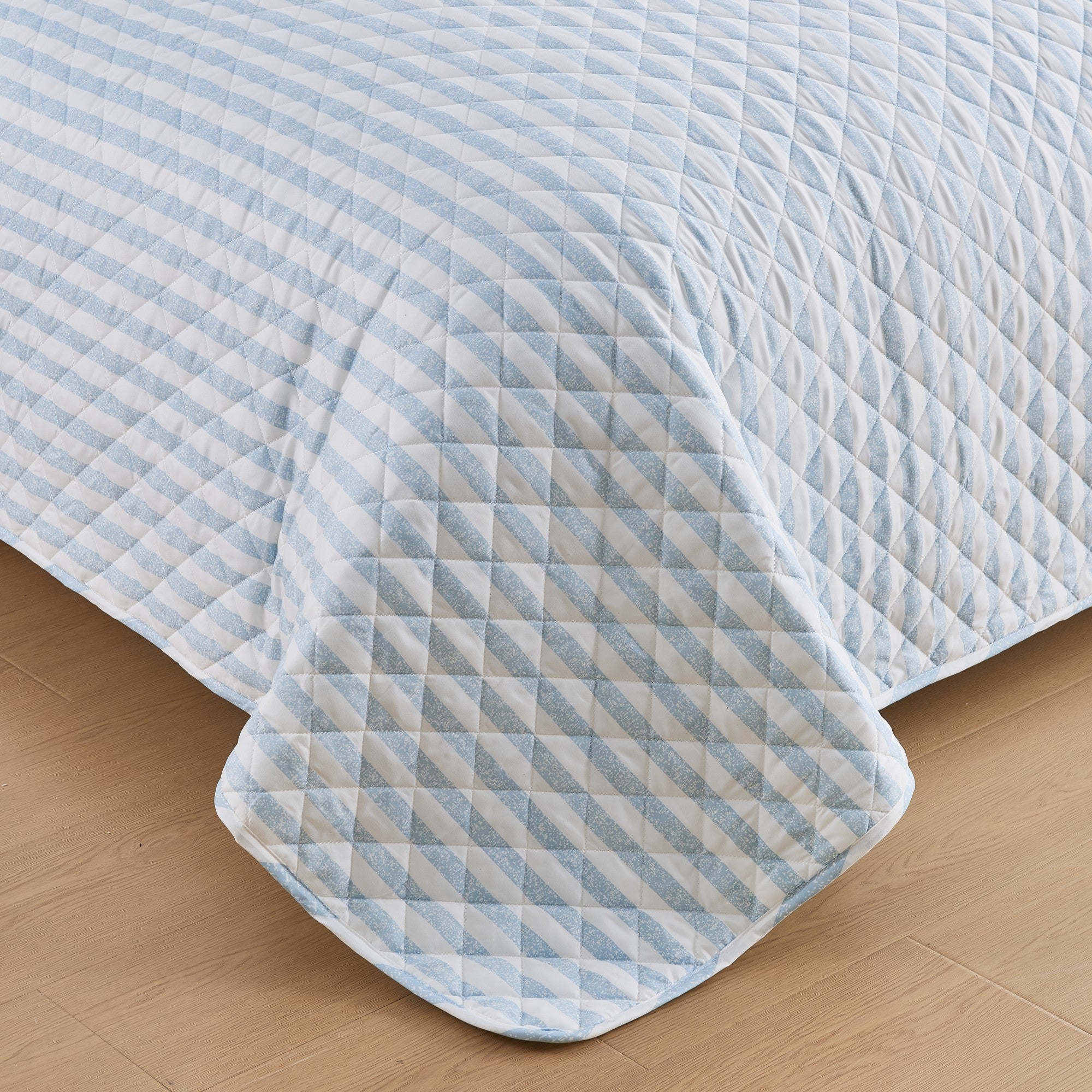 Close-up of Avery Collection blue and white striped quilt featuring diamond stitch quilting detail