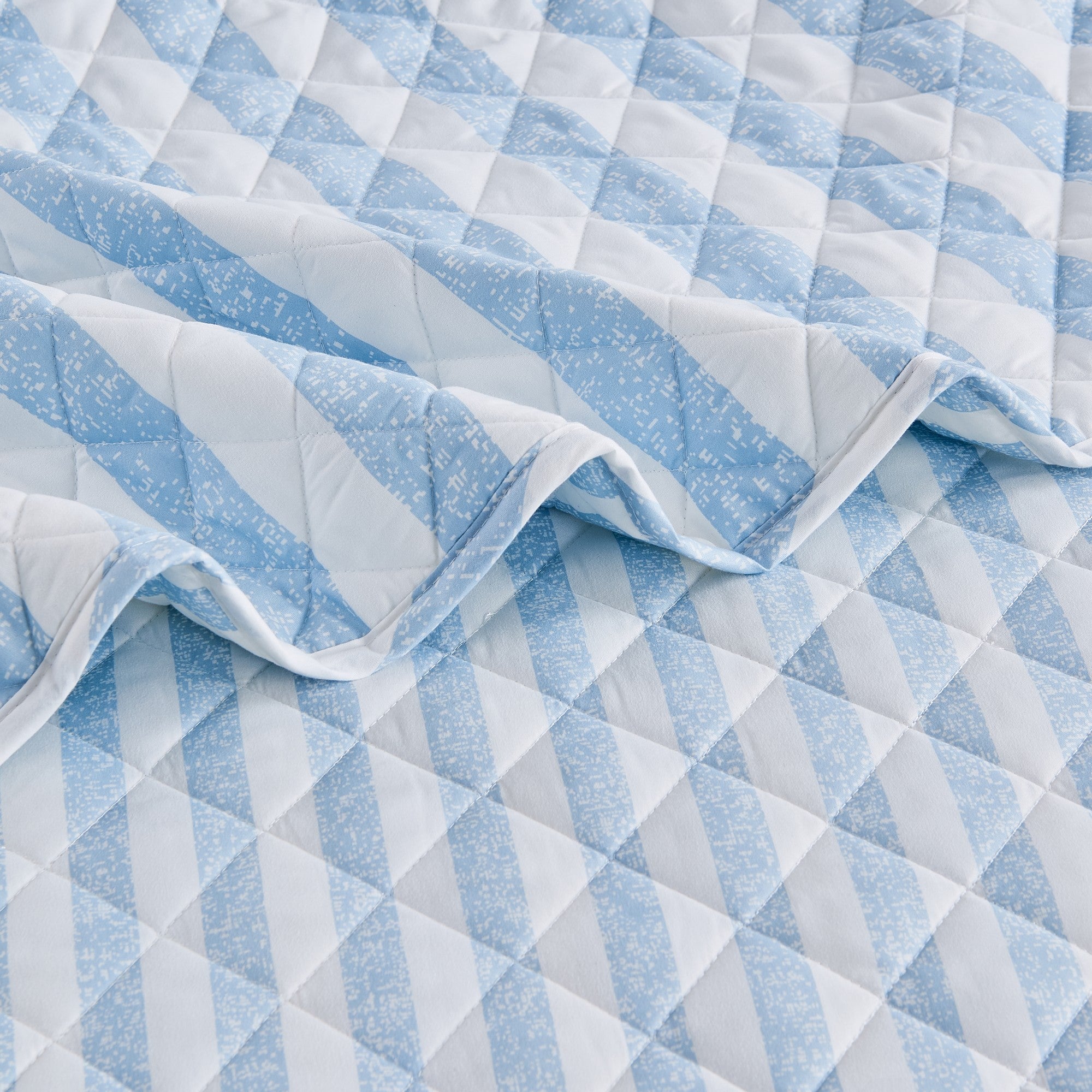 Close-up of Avery Collection blue and white striped quilt showcasing diamond quilting and soft microfiber fabric