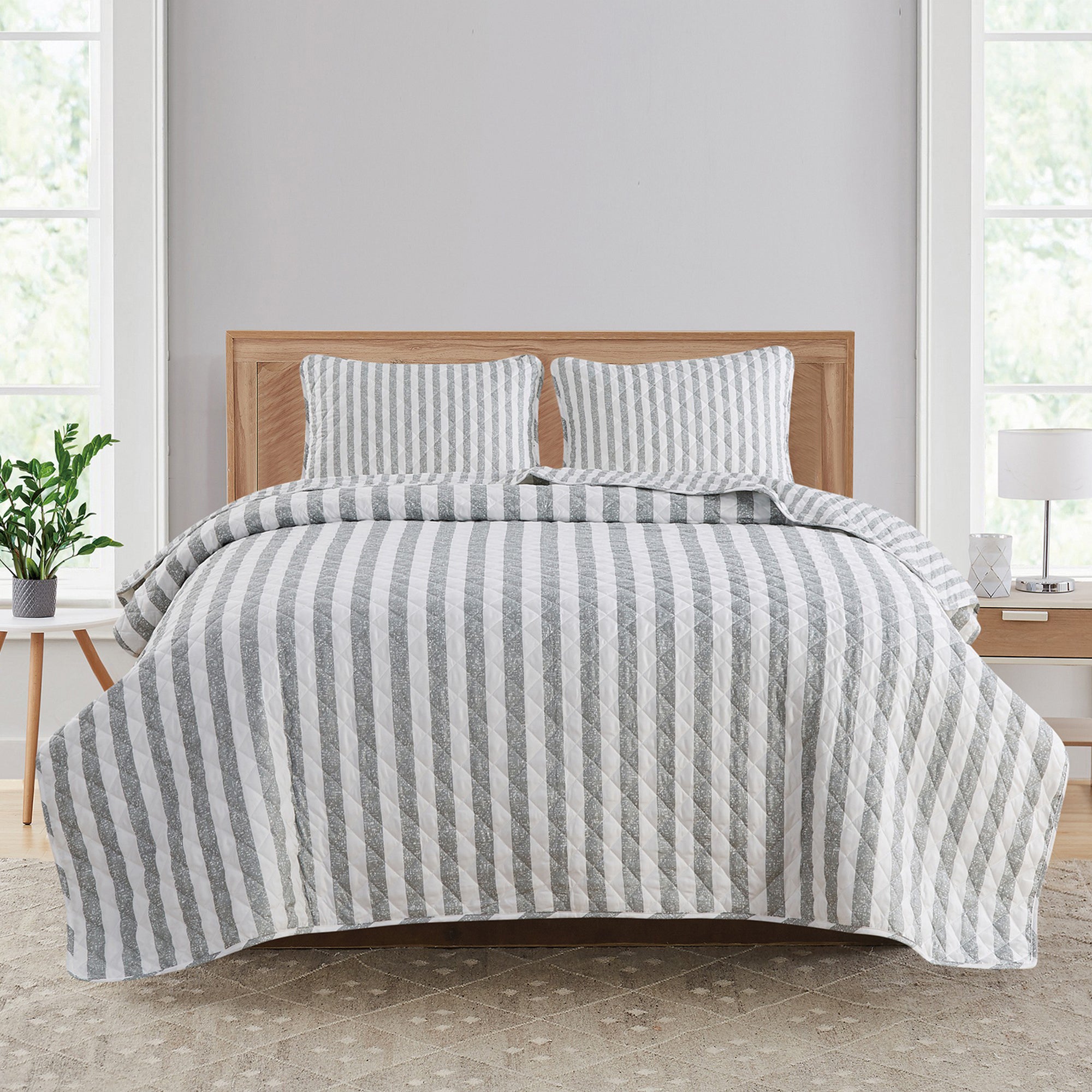 Avery Collection reversible gray and white striped quilt set displayed on a bed with matching pillow shams