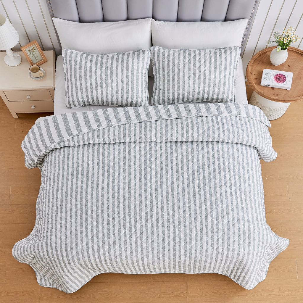 Overhead view of Avery Collection reversible gray and white striped quilt set with matching pillow shams