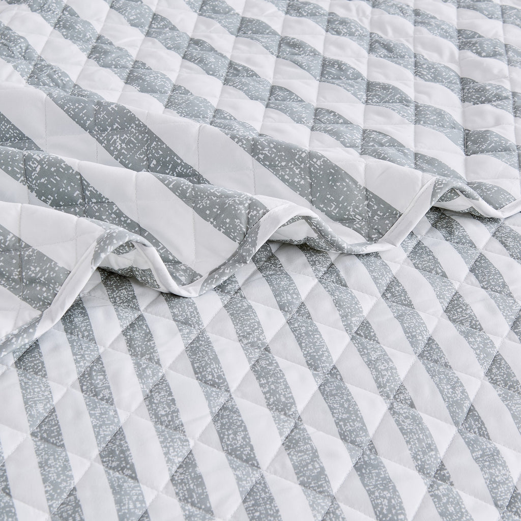 Close-up of Avery Collection gray and white striped quilt showcasing diamond quilting and soft microfiber fabric