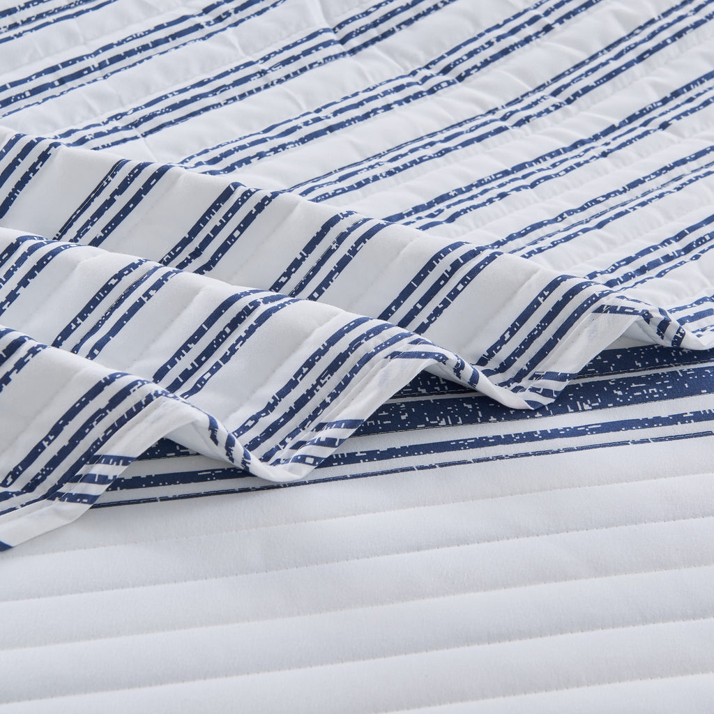Close-up detail of the Harper Collection quilt showcasing navy blue striped fabric, quilted stitching, and soft microfiber construction.