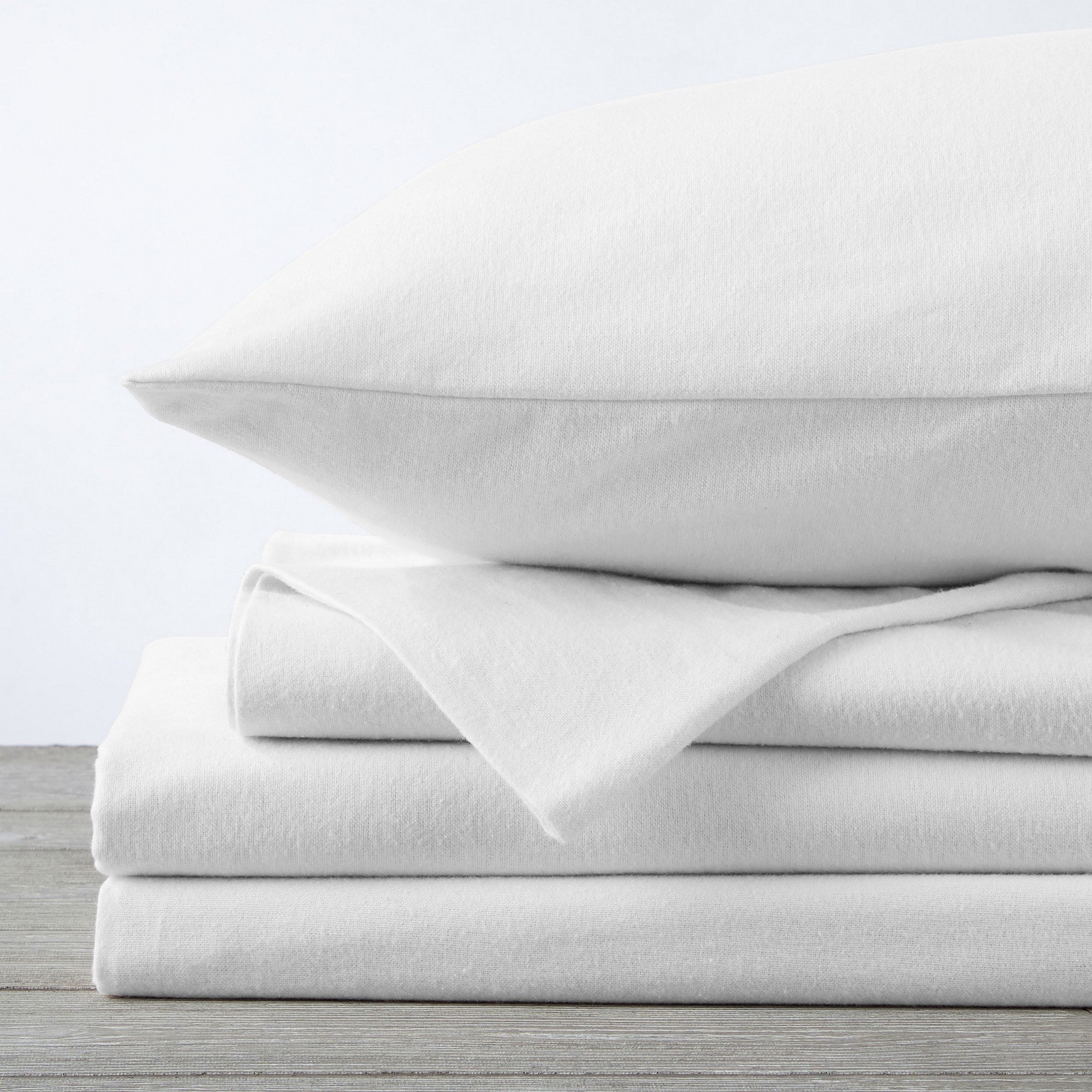 Chalet Collection Solid Flannel Sheet Set in assorted solid colors, featuring ultra-soft 100% Turkish cotton flannel bedding with coordinating pillowcases and fitted sheets, shown styled on beds and folded for detail views.