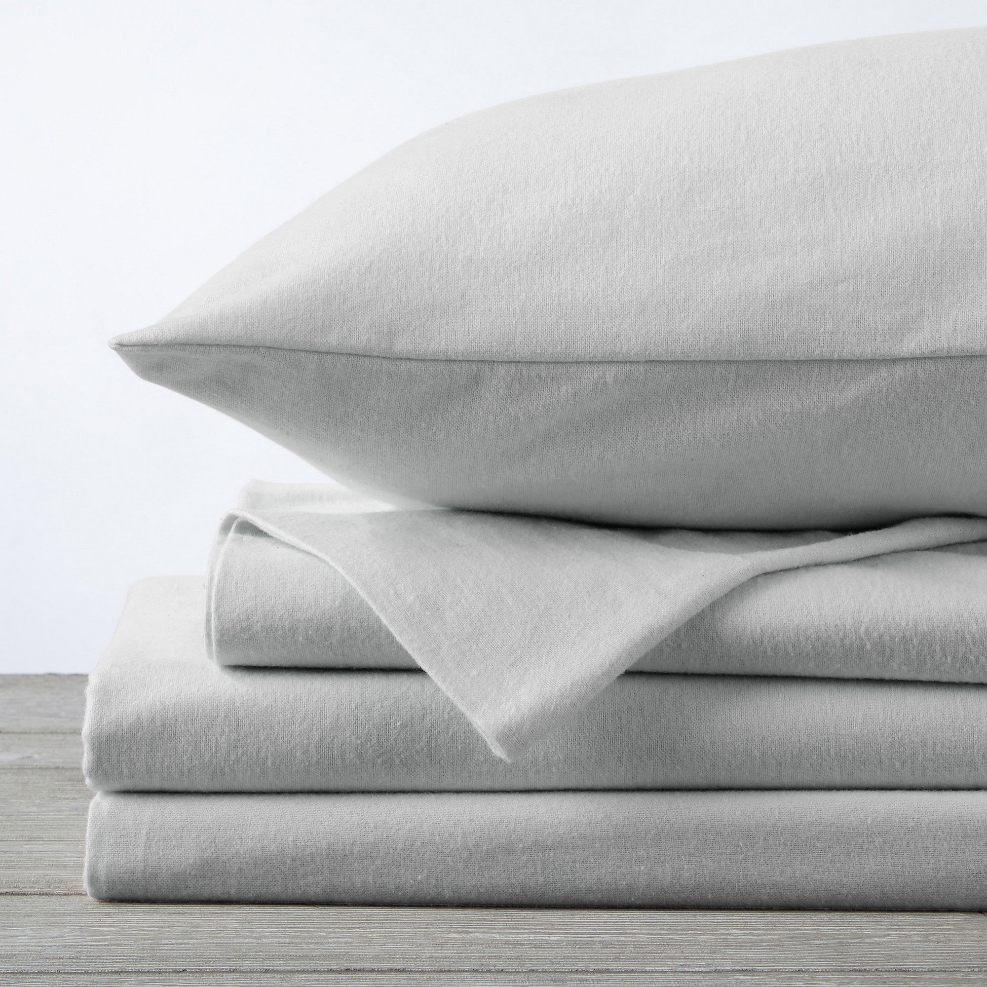 Chalet Collection Solid Flannel Sheet Set in assorted solid colors, featuring ultra-soft 100% Turkish cotton flannel bedding with coordinating pillowcases and fitted sheets, shown styled on beds and folded for detail views.